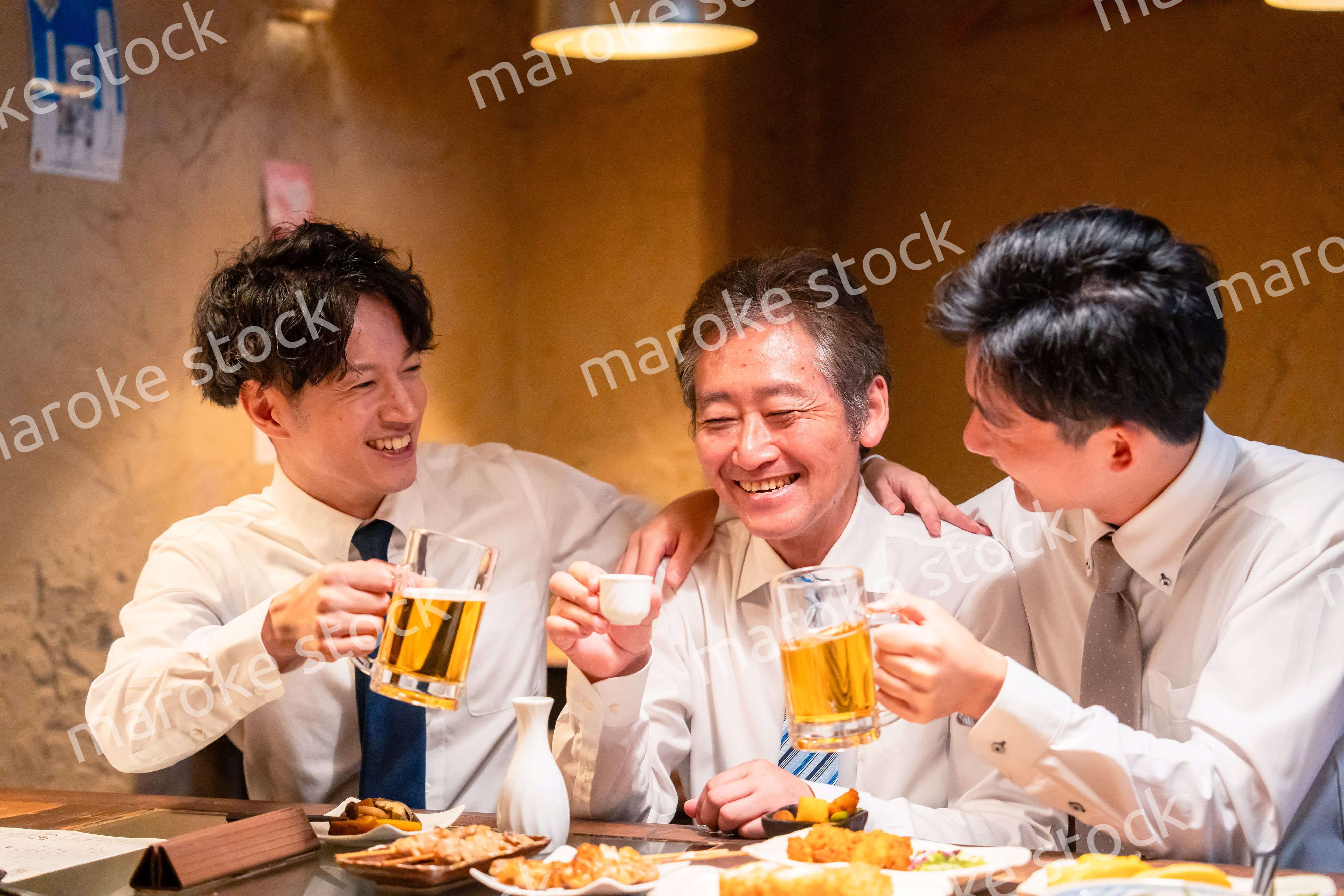 上司と肩を組みながら居酒屋で飲むサラリーマン