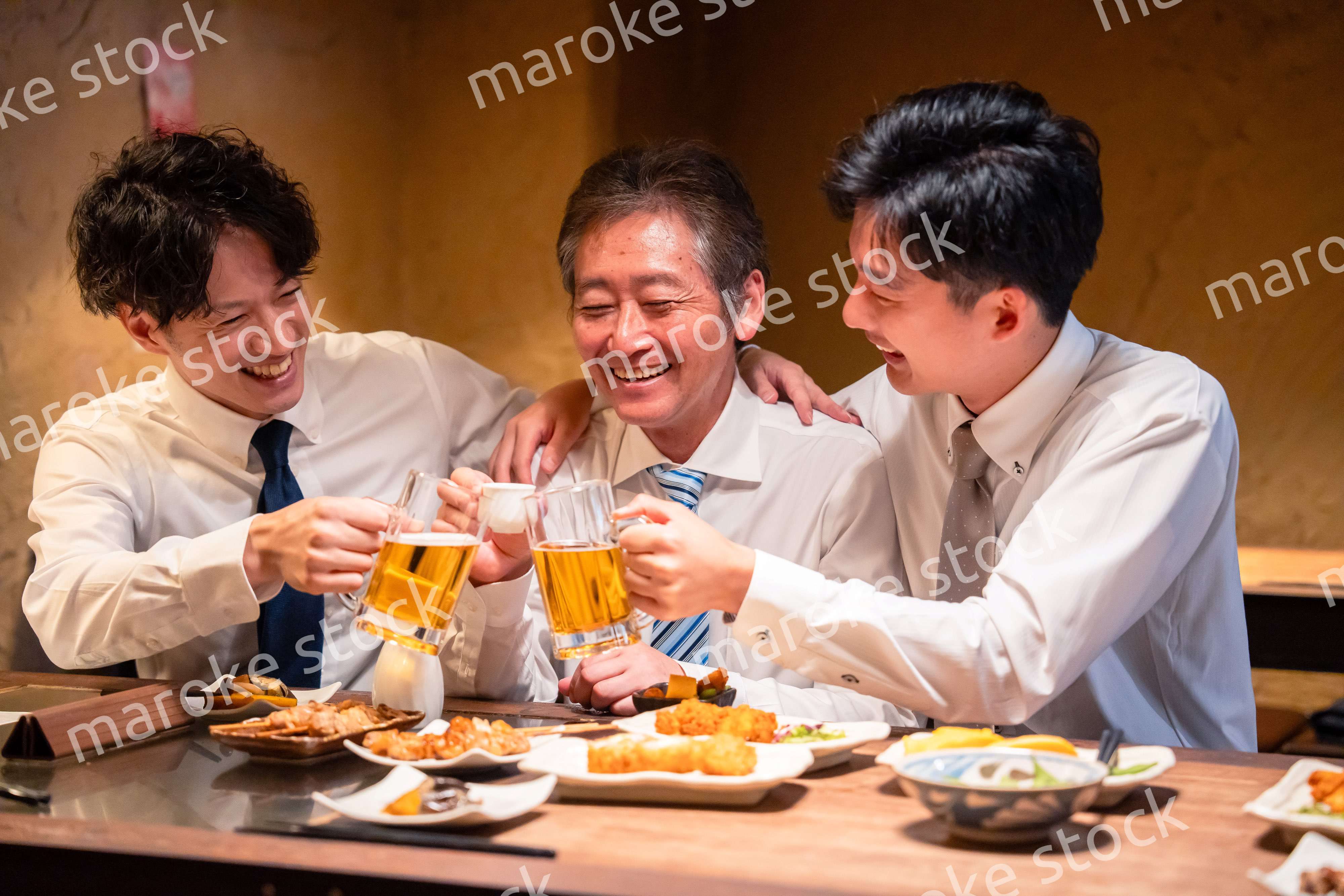上司と肩を組みながら居酒屋で飲むサラリーマン