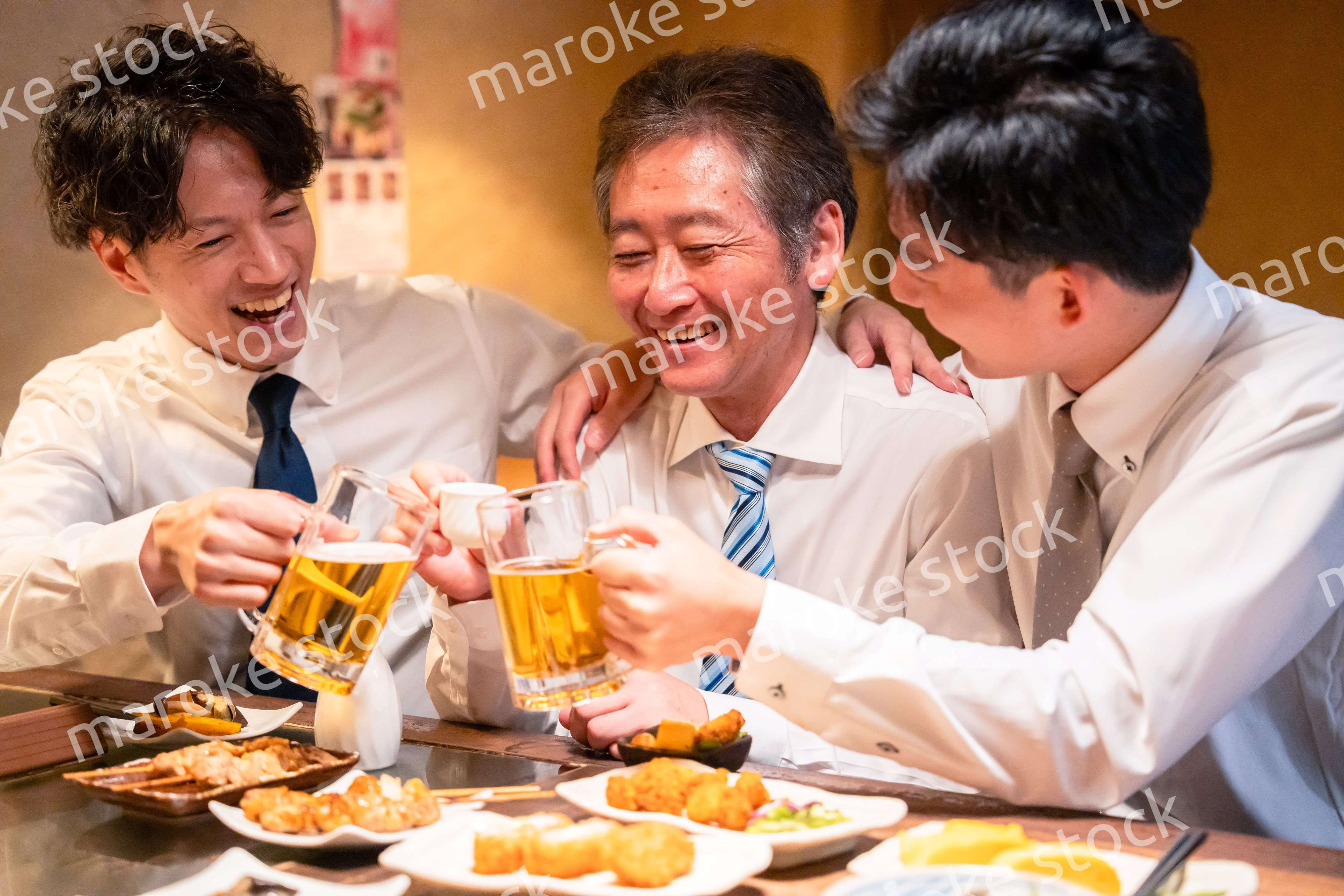 上司と肩を組みながら居酒屋で飲むサラリーマン