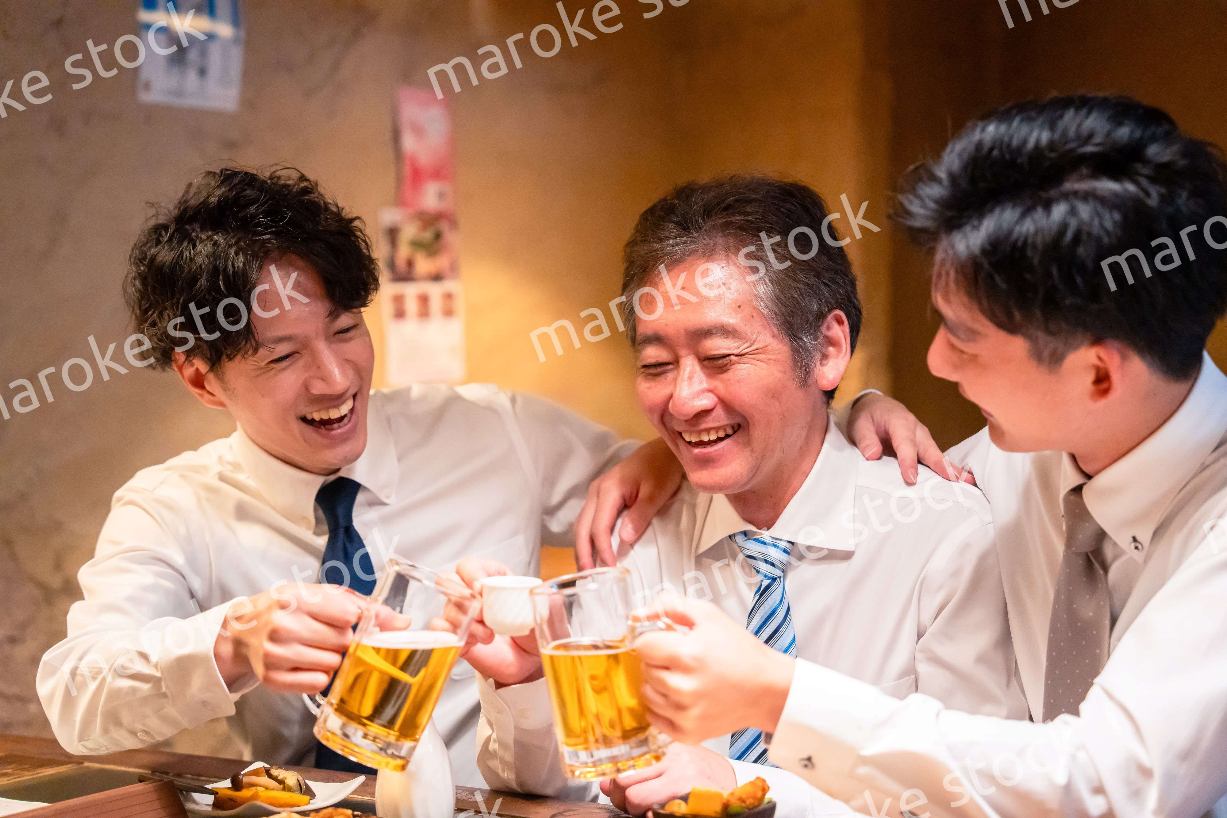 上司と肩を組みながら居酒屋で飲むサラリーマン