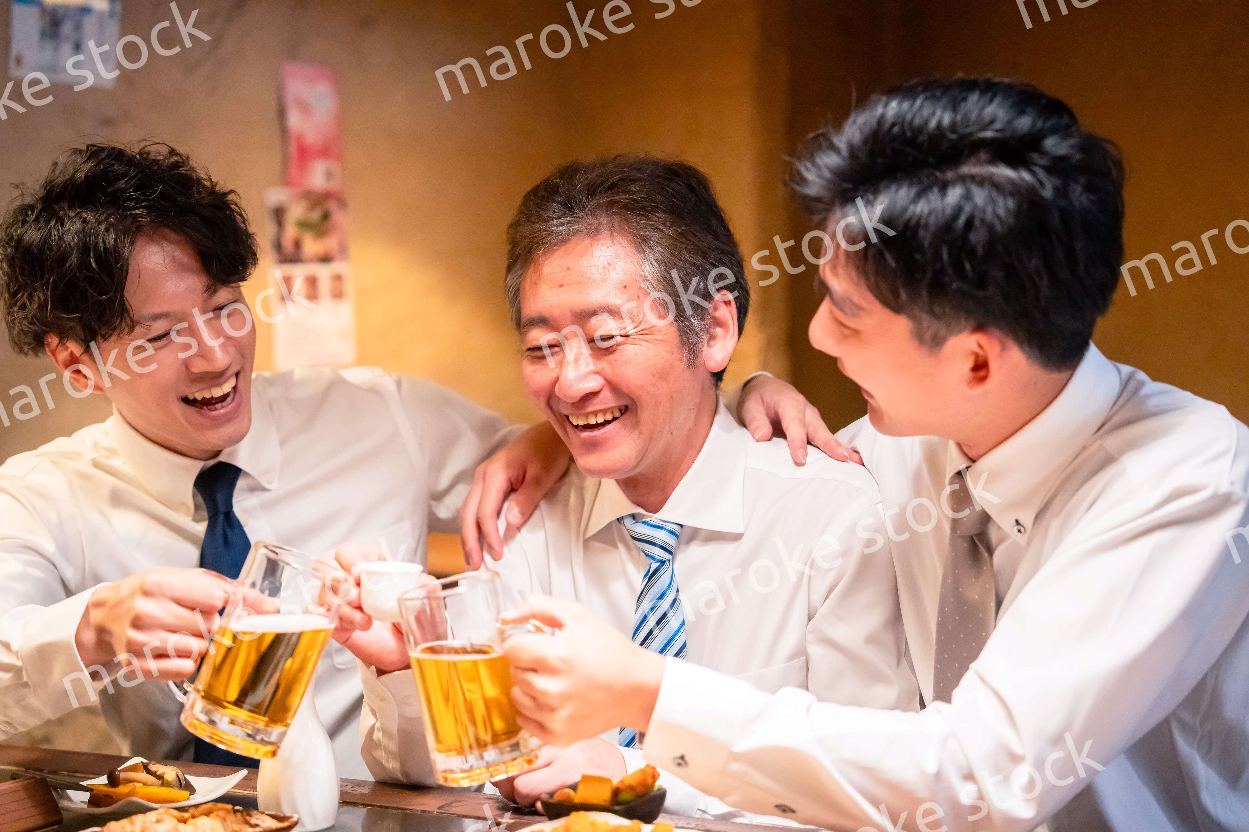 上司と肩を組みながら居酒屋で飲むサラリーマン