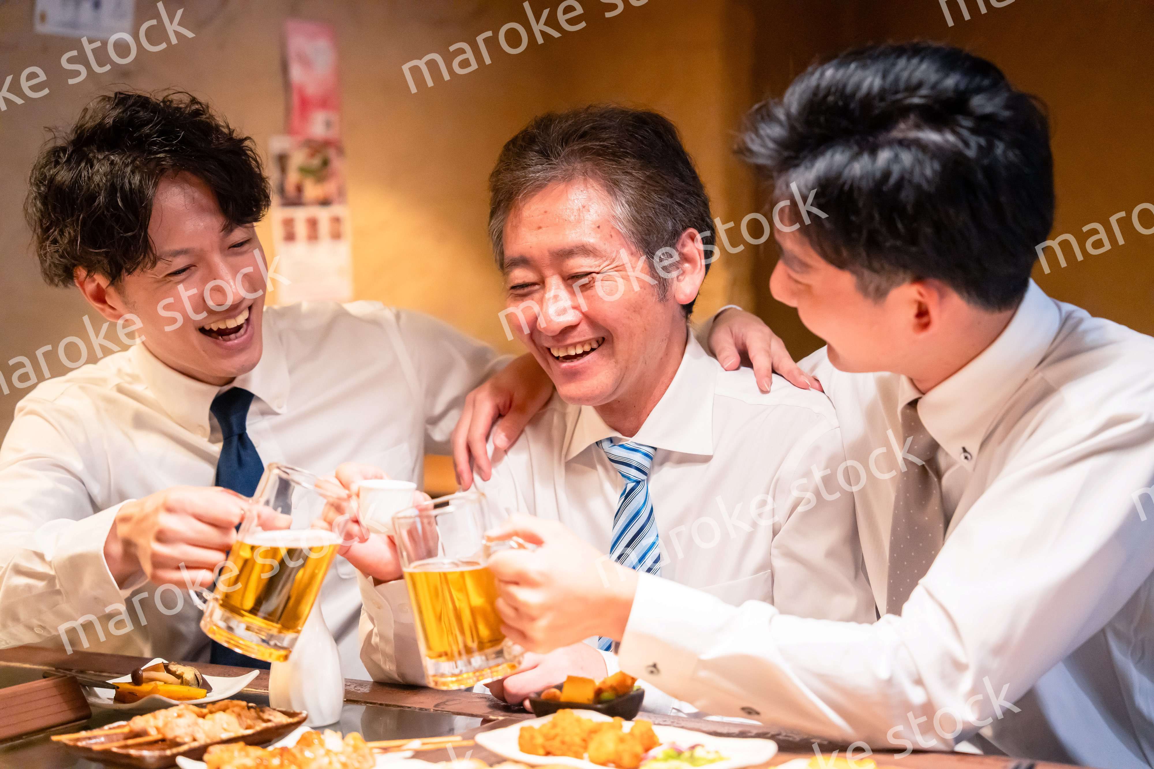 上司と肩を組みながら居酒屋で飲むサラリーマン