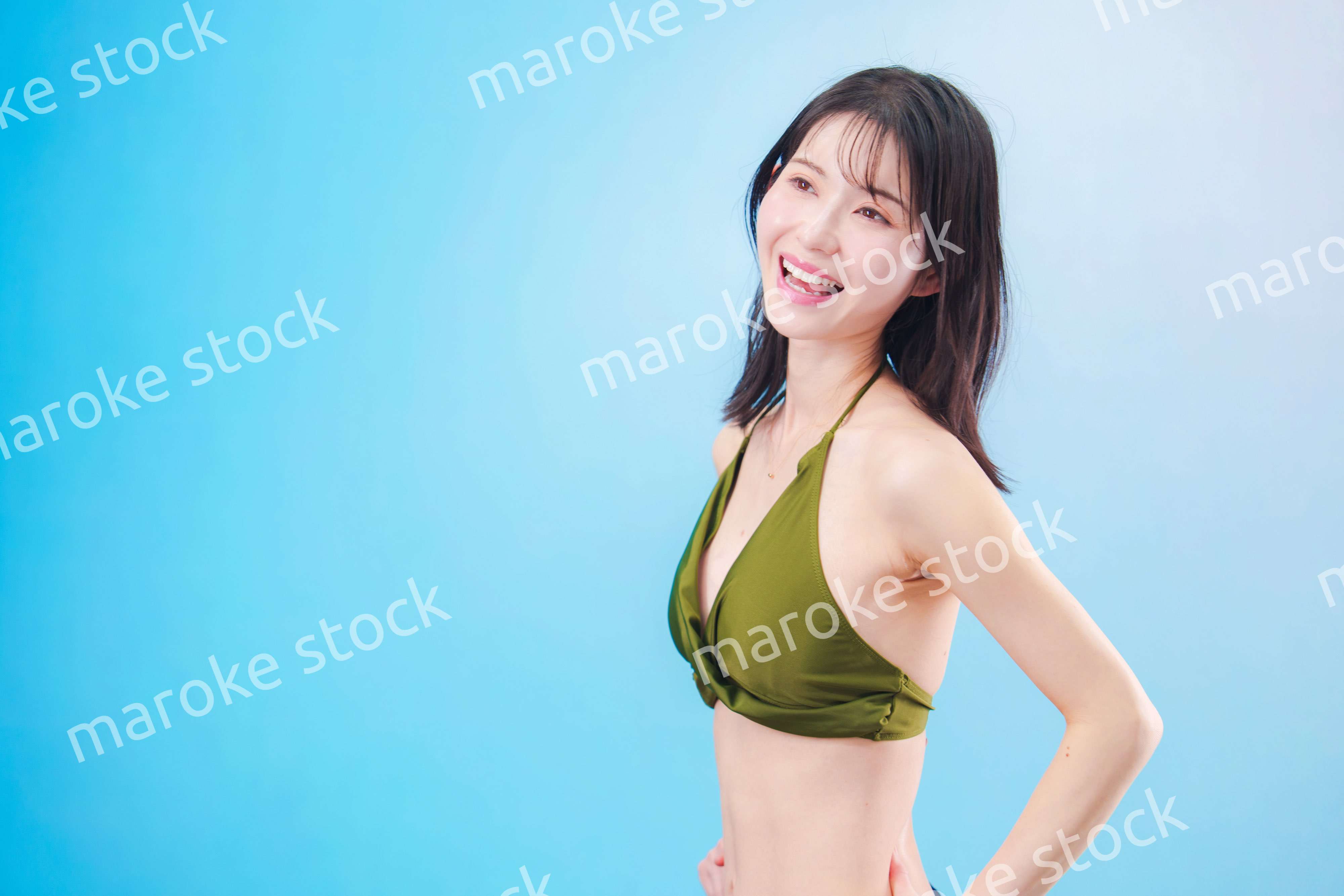 水着を着て夏を満喫する女性（水色背景）