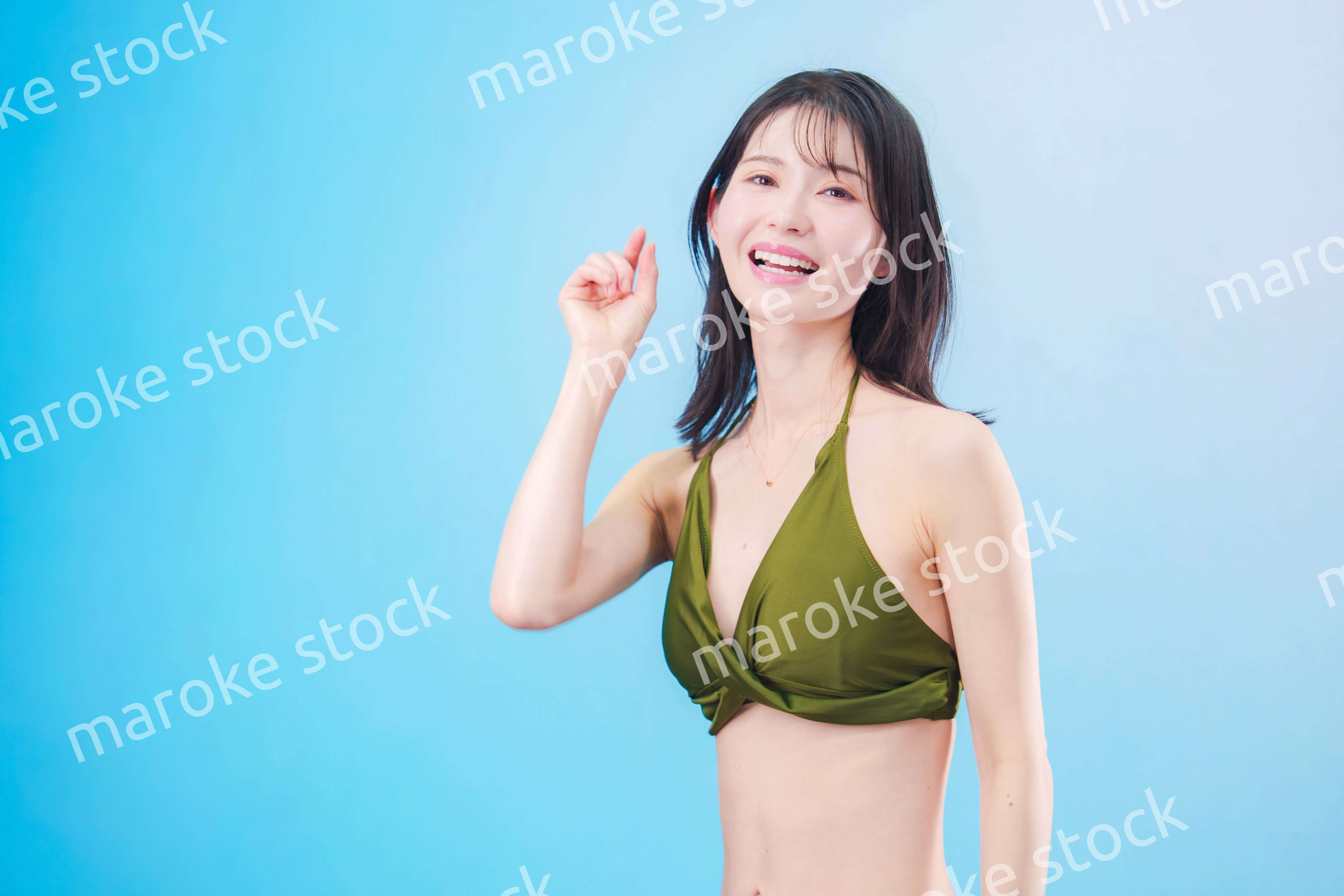 水着を着て夏を満喫する女性（水色背景）