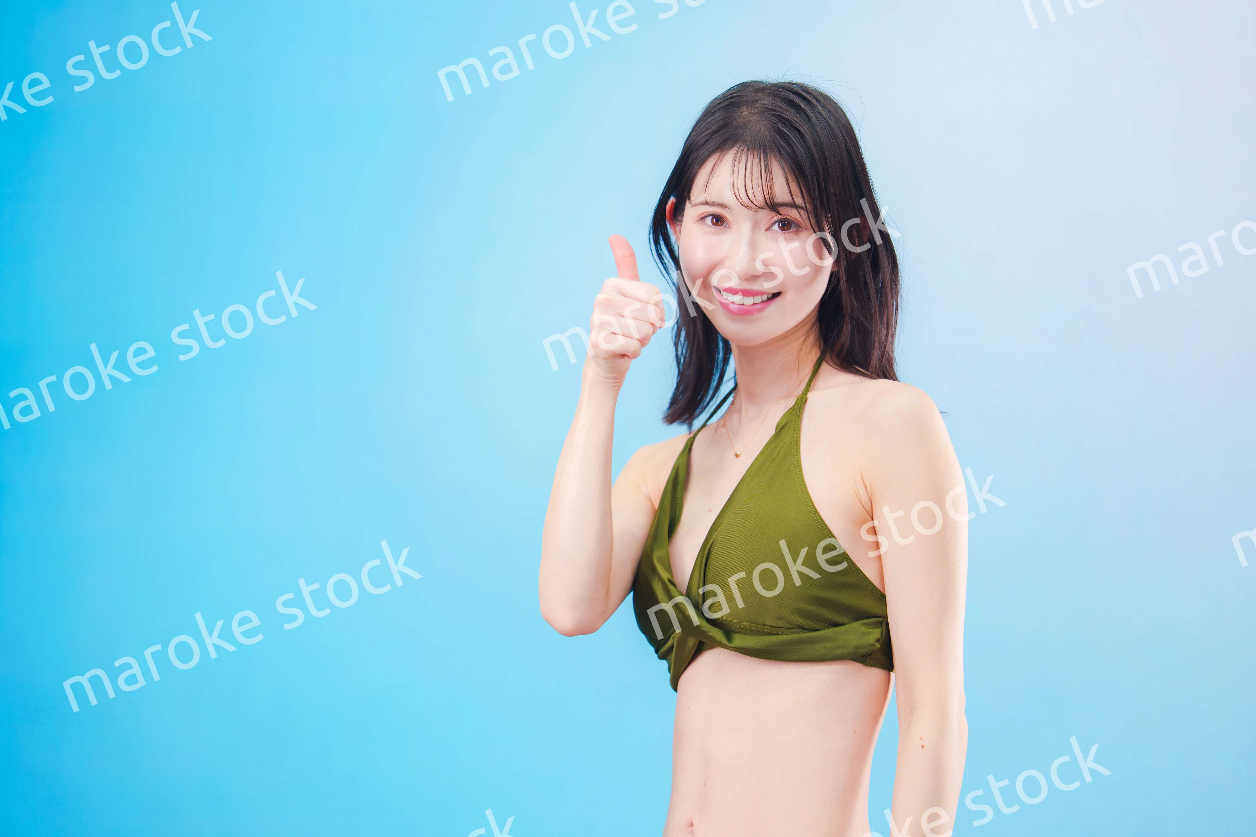 水着を着て夏を満喫する女性（水色背景）