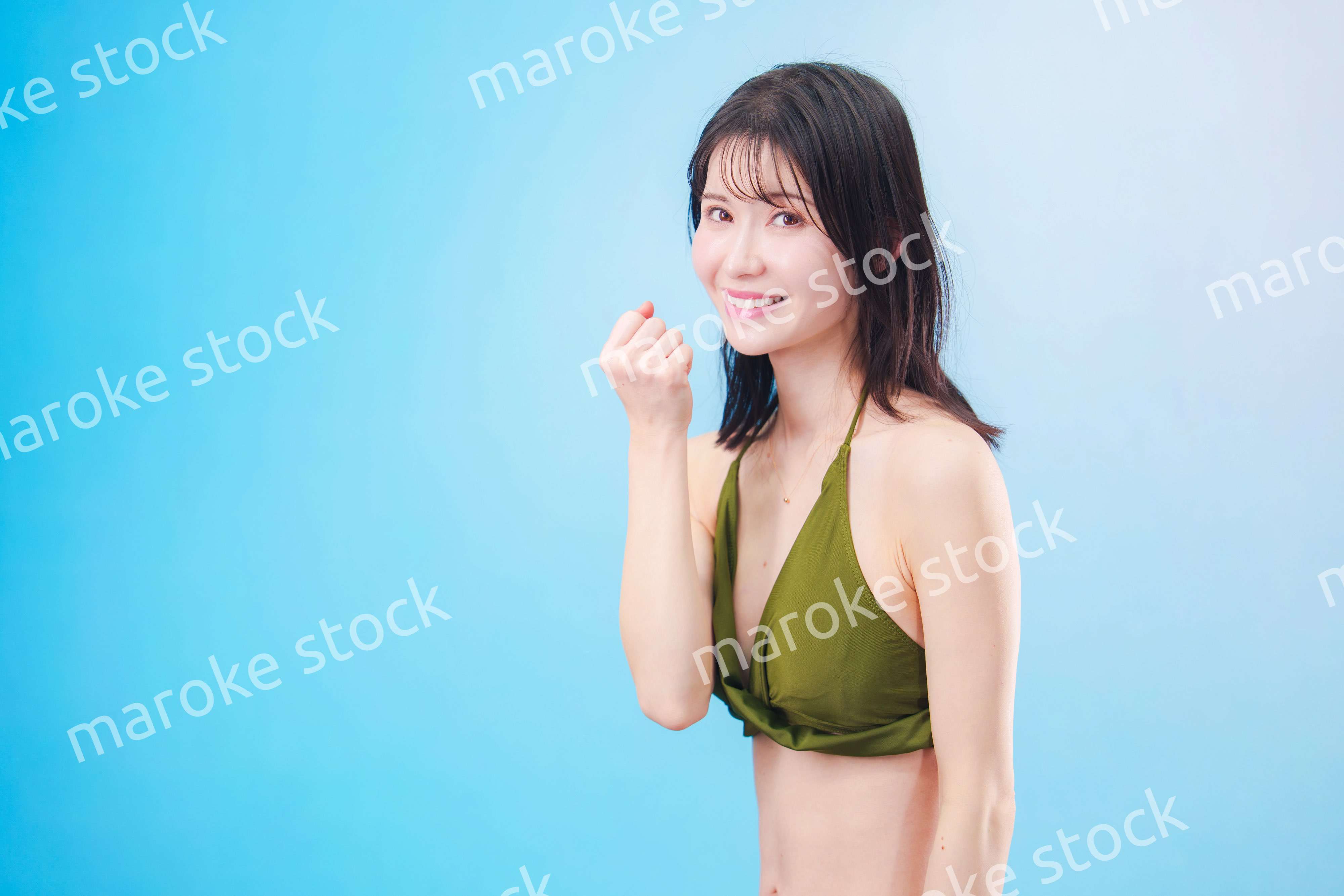 水着を着て夏を満喫する女性（水色背景）