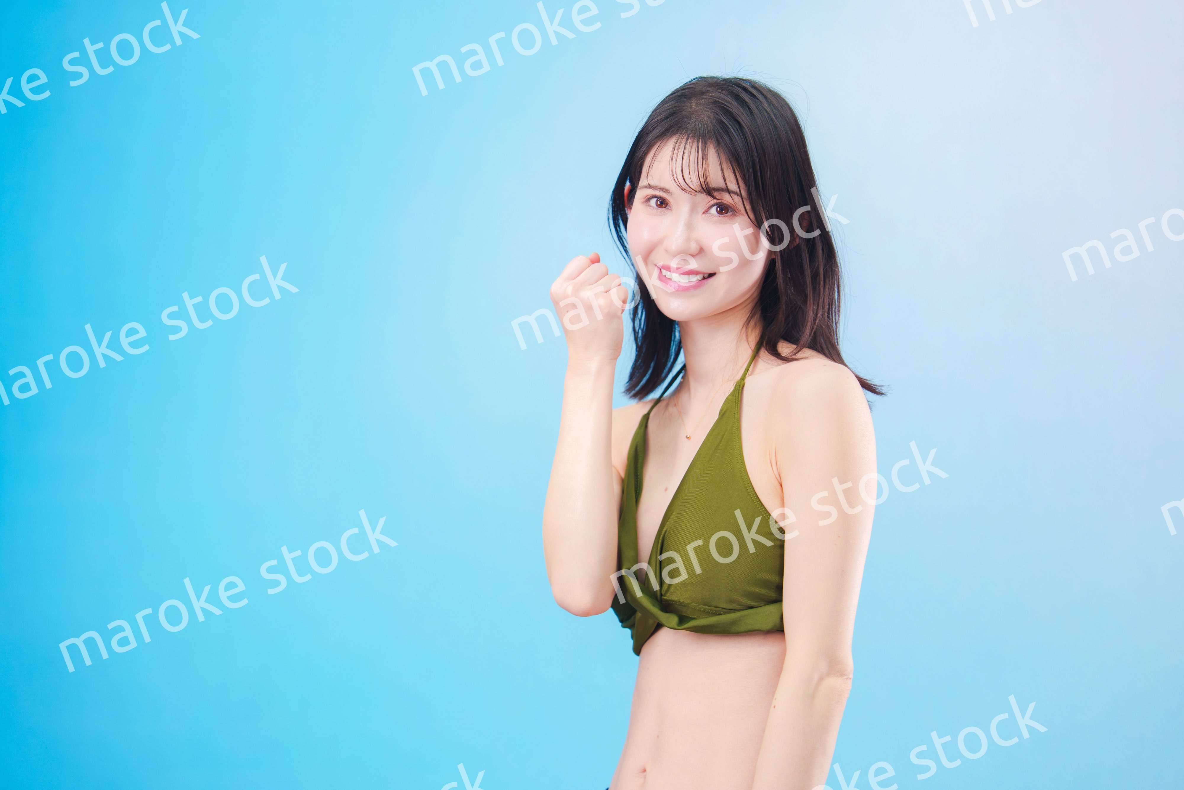 水着を着て夏を満喫する女性（水色背景）