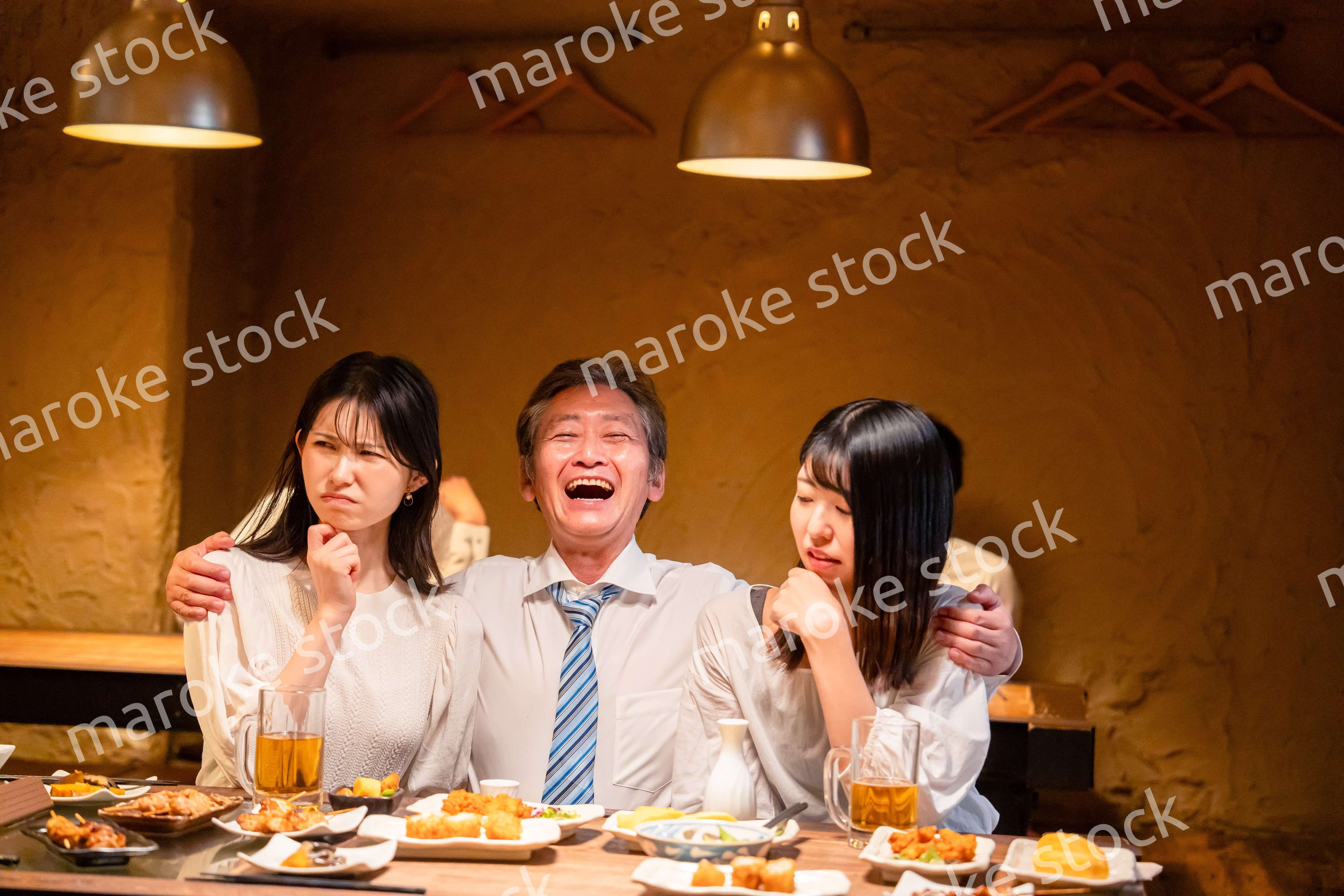 宴会の席で女性と肩を組むビジネスマン