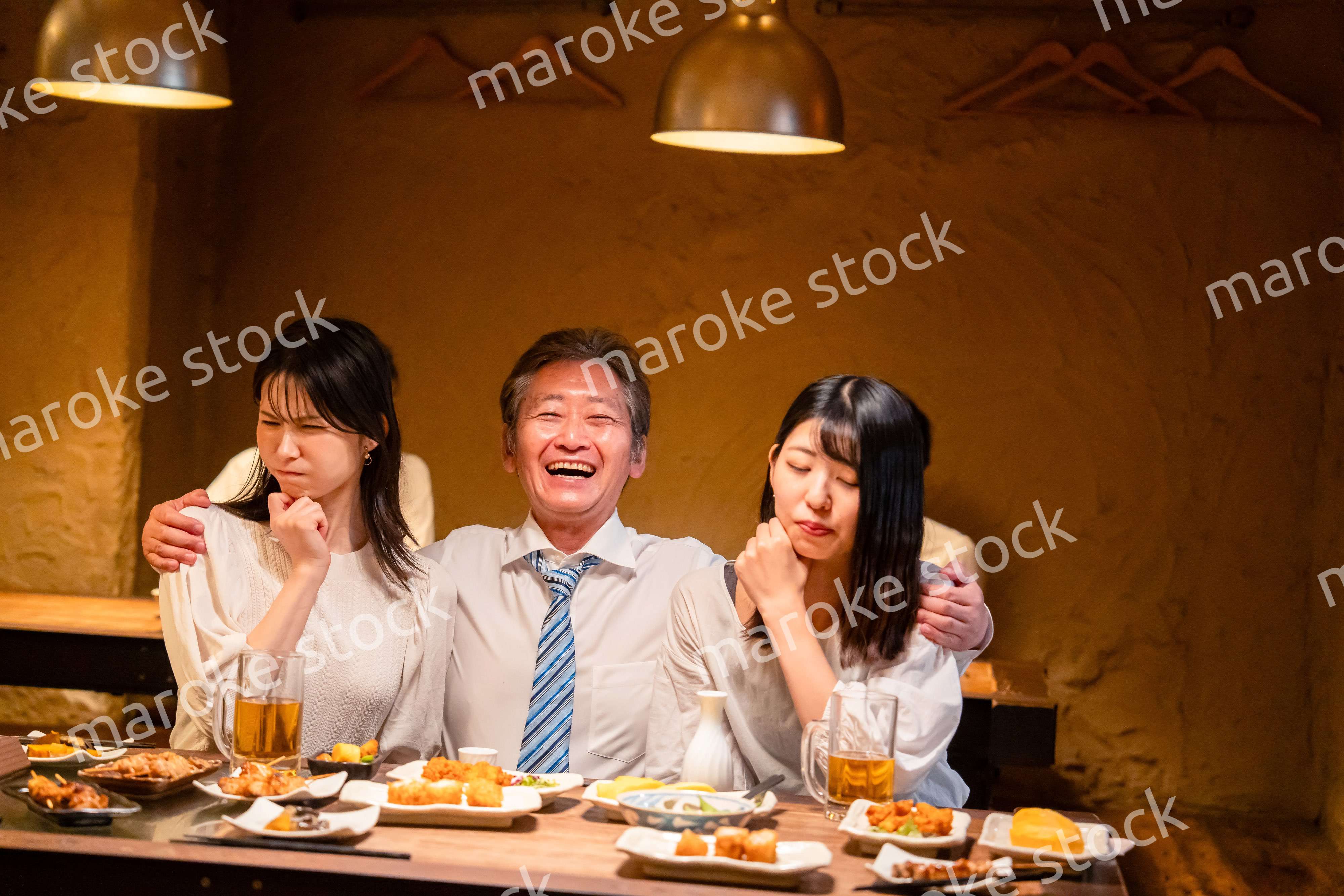 宴会の席で女性と肩を組むビジネスマン