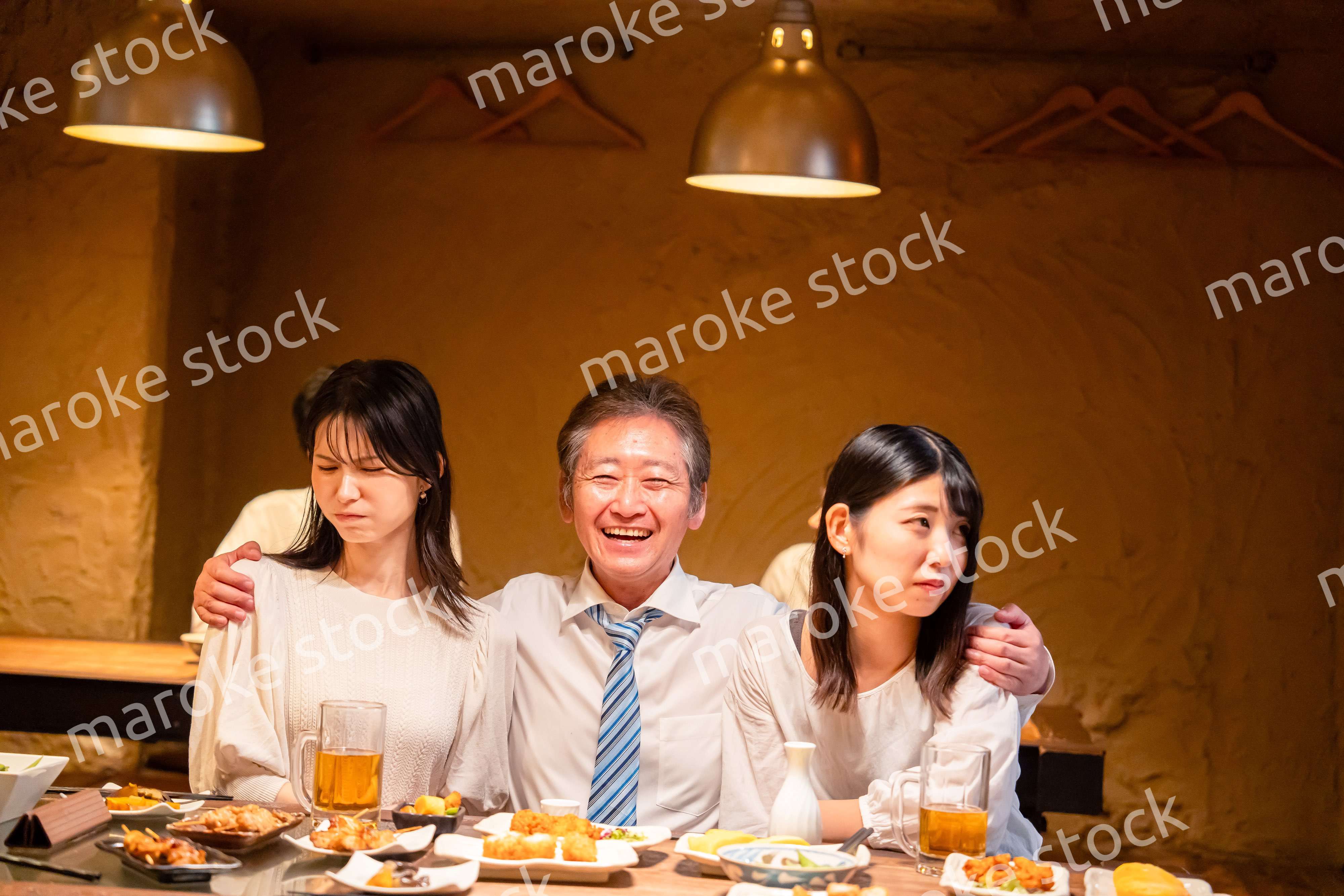 宴会の席で女性と肩を組むビジネスマン