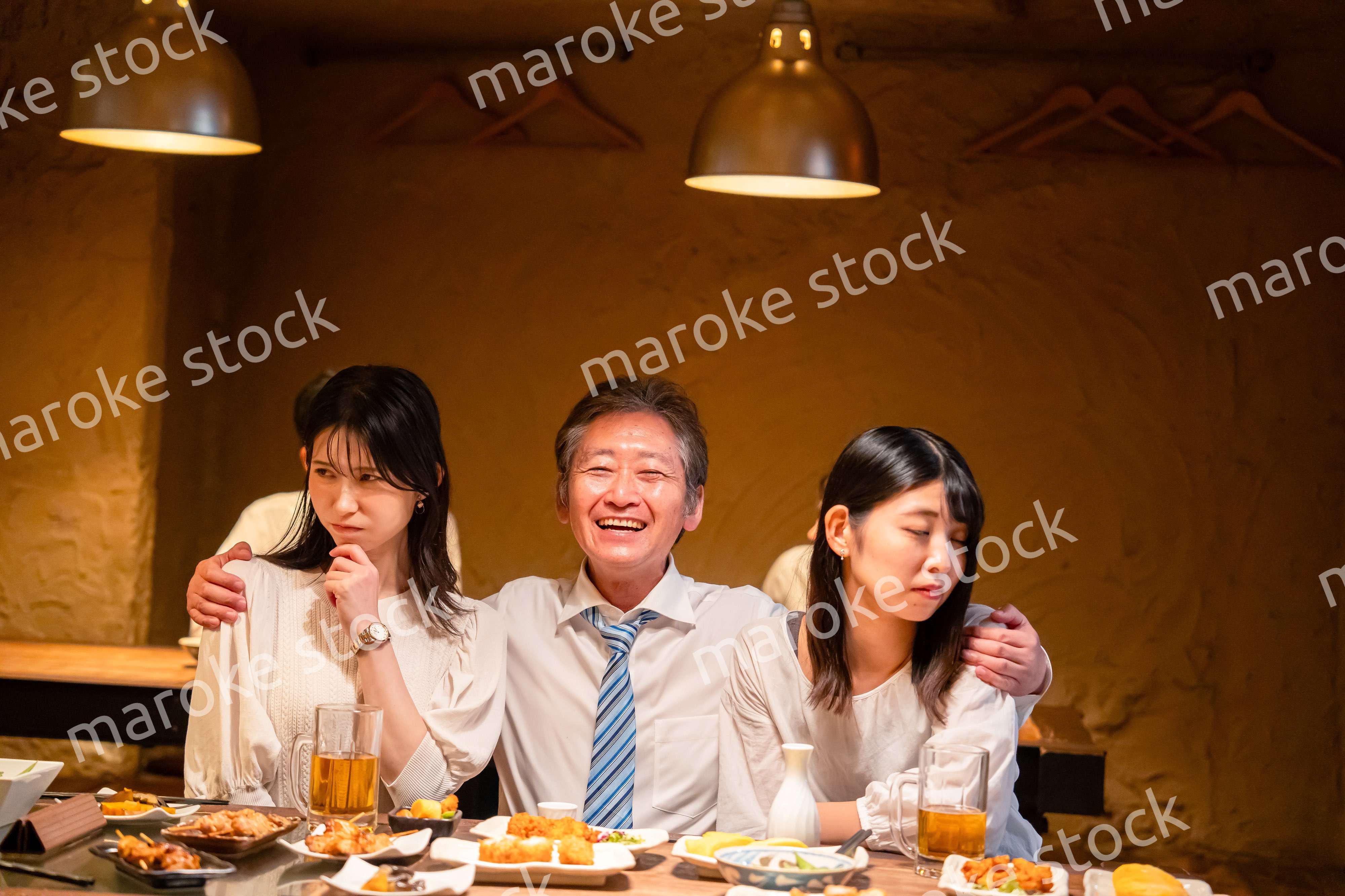 宴会の席で女性と肩を組むビジネスマン