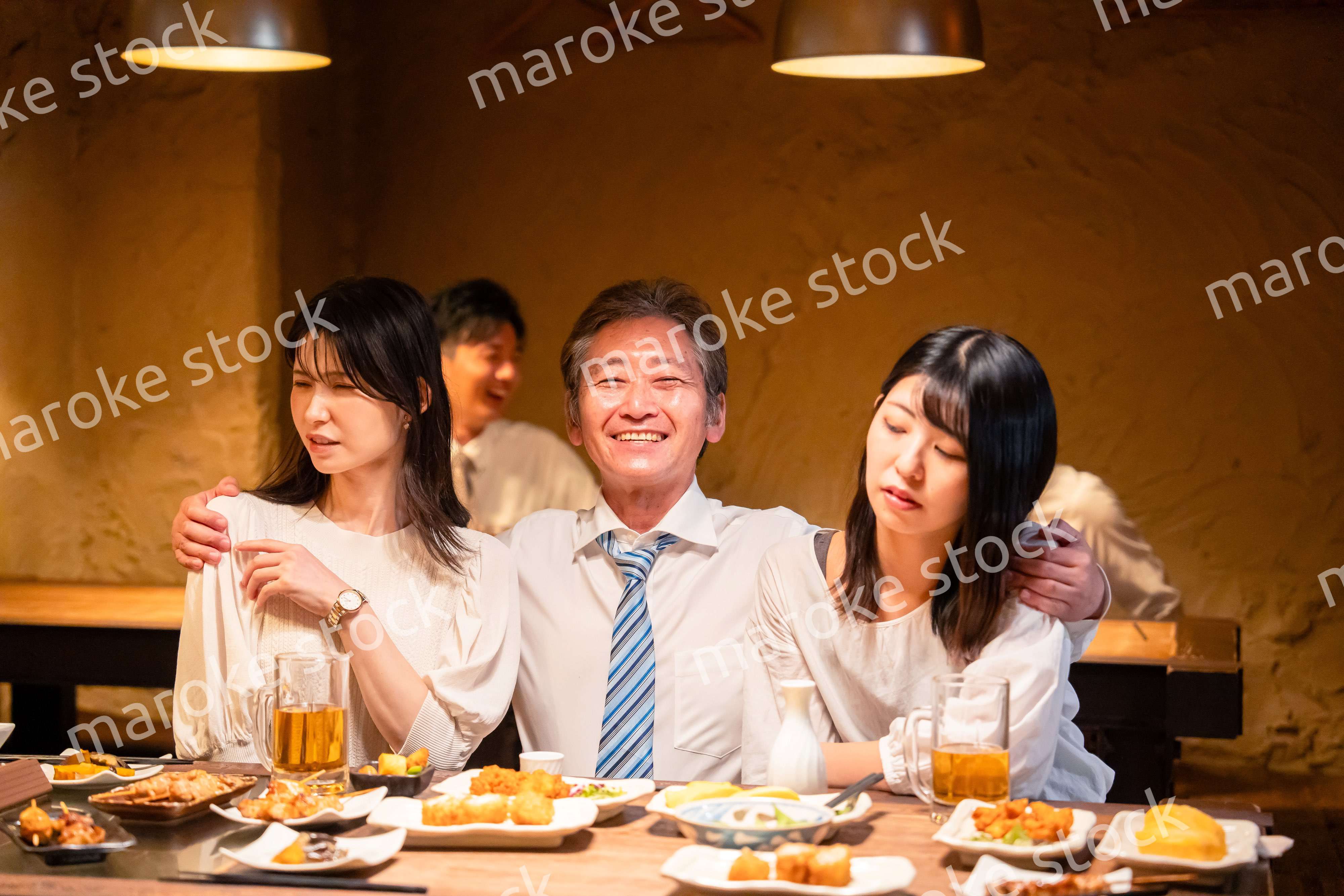 宴会の席で女性と肩を組むビジネスマン