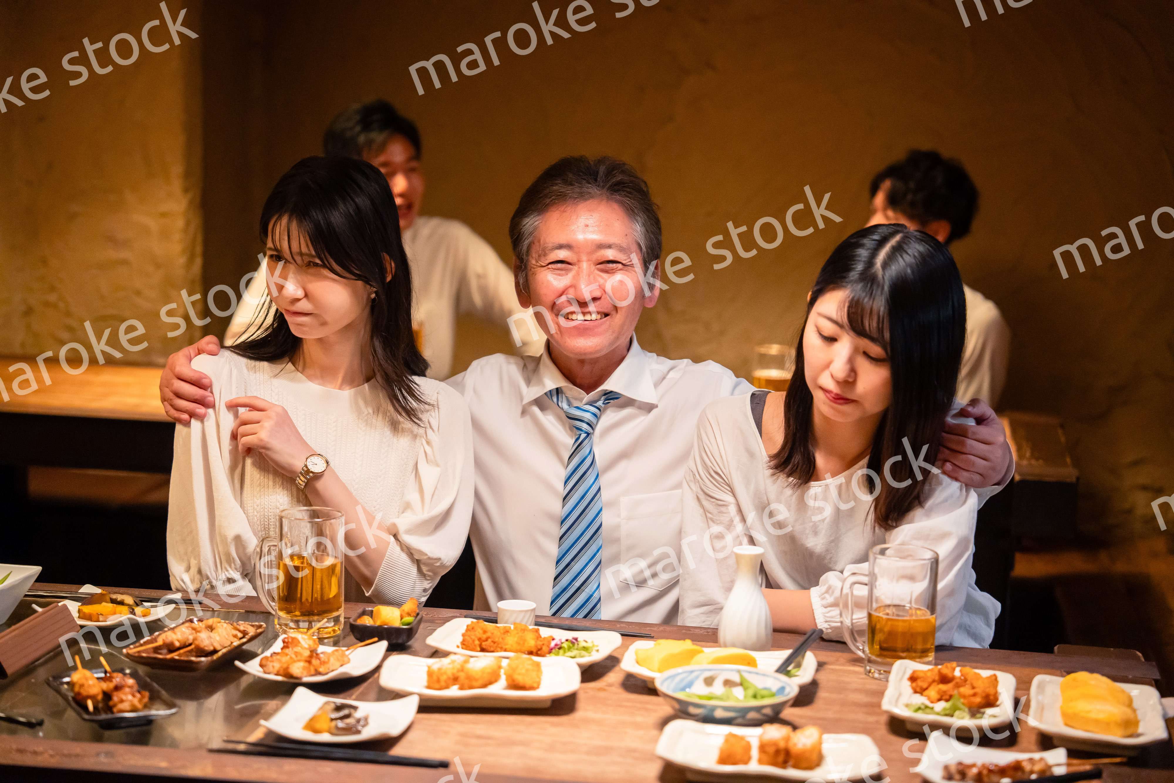 宴会の席で女性と肩を組むビジネスマン