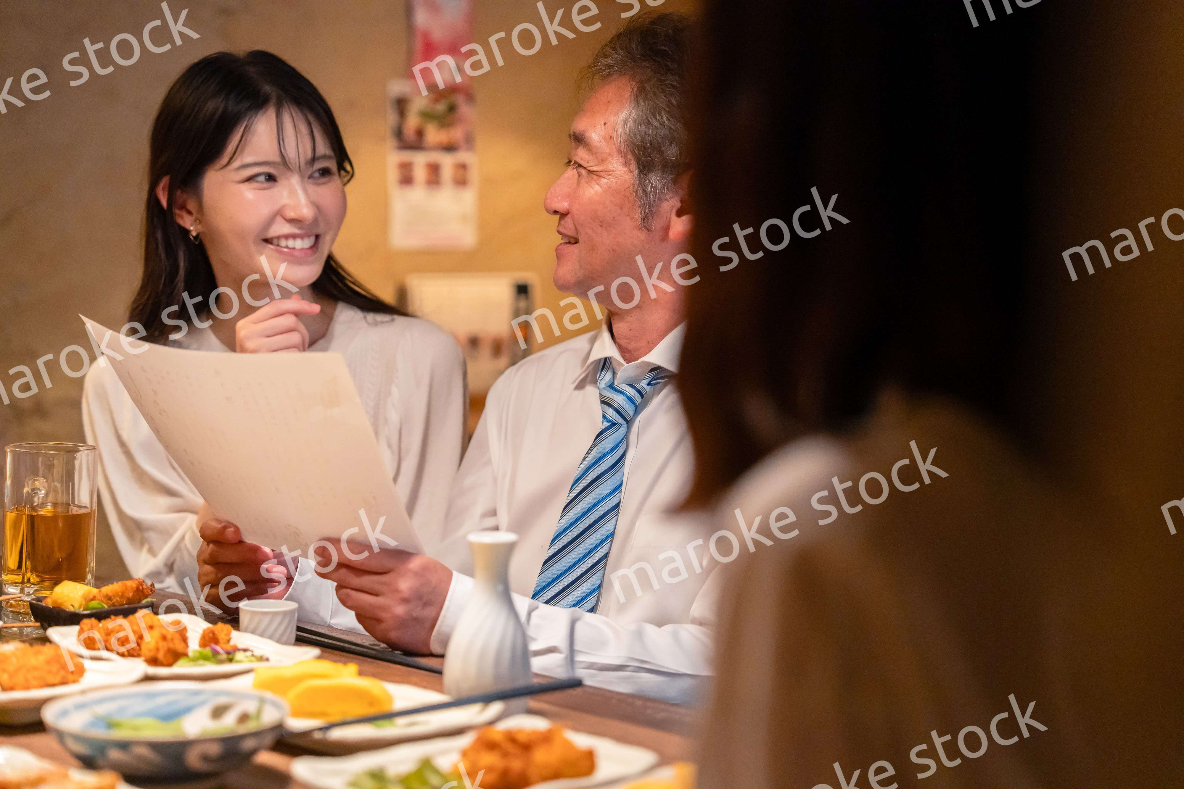 若い女性と二人でお酒を飲む男性