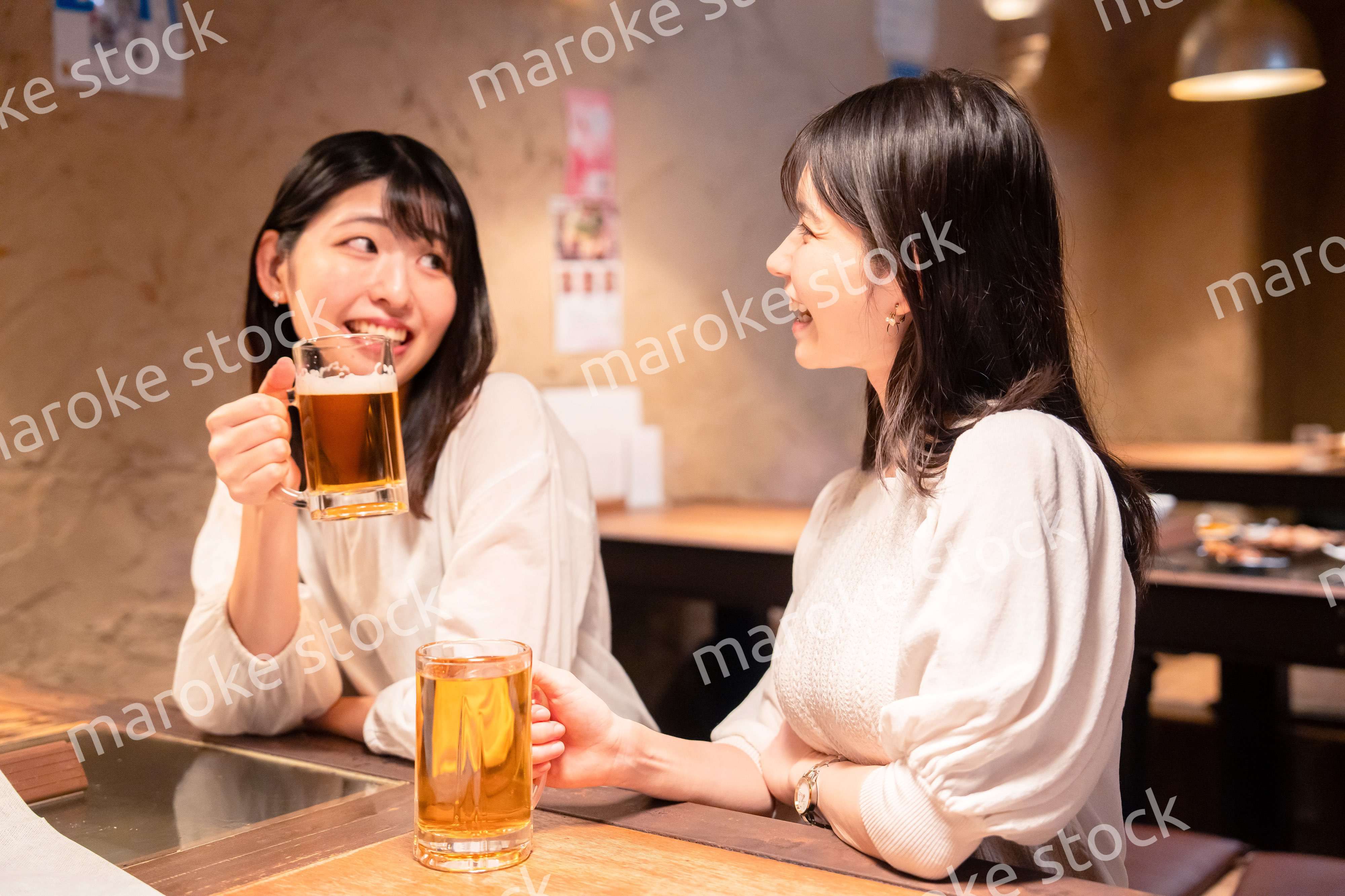 居酒屋で女子会をする二人の女性