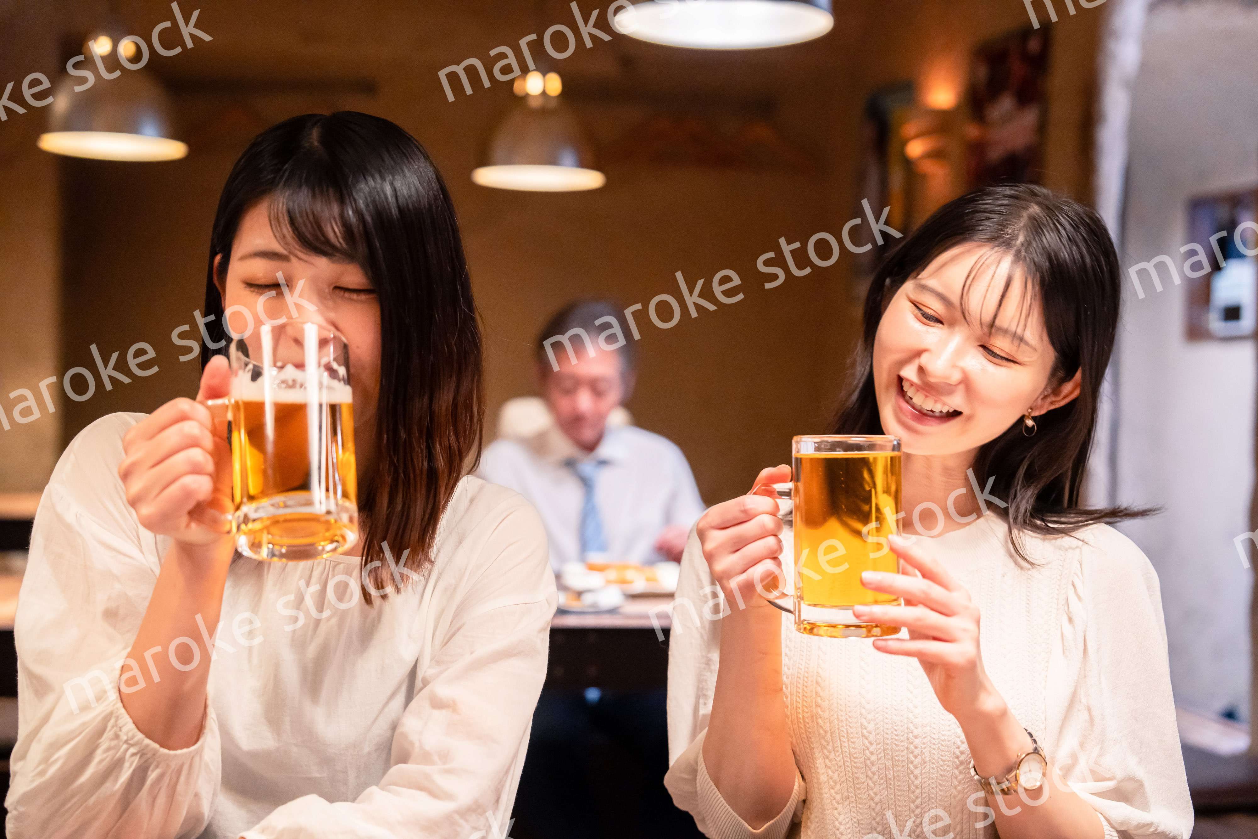 居酒屋で女子会をする二人の女性