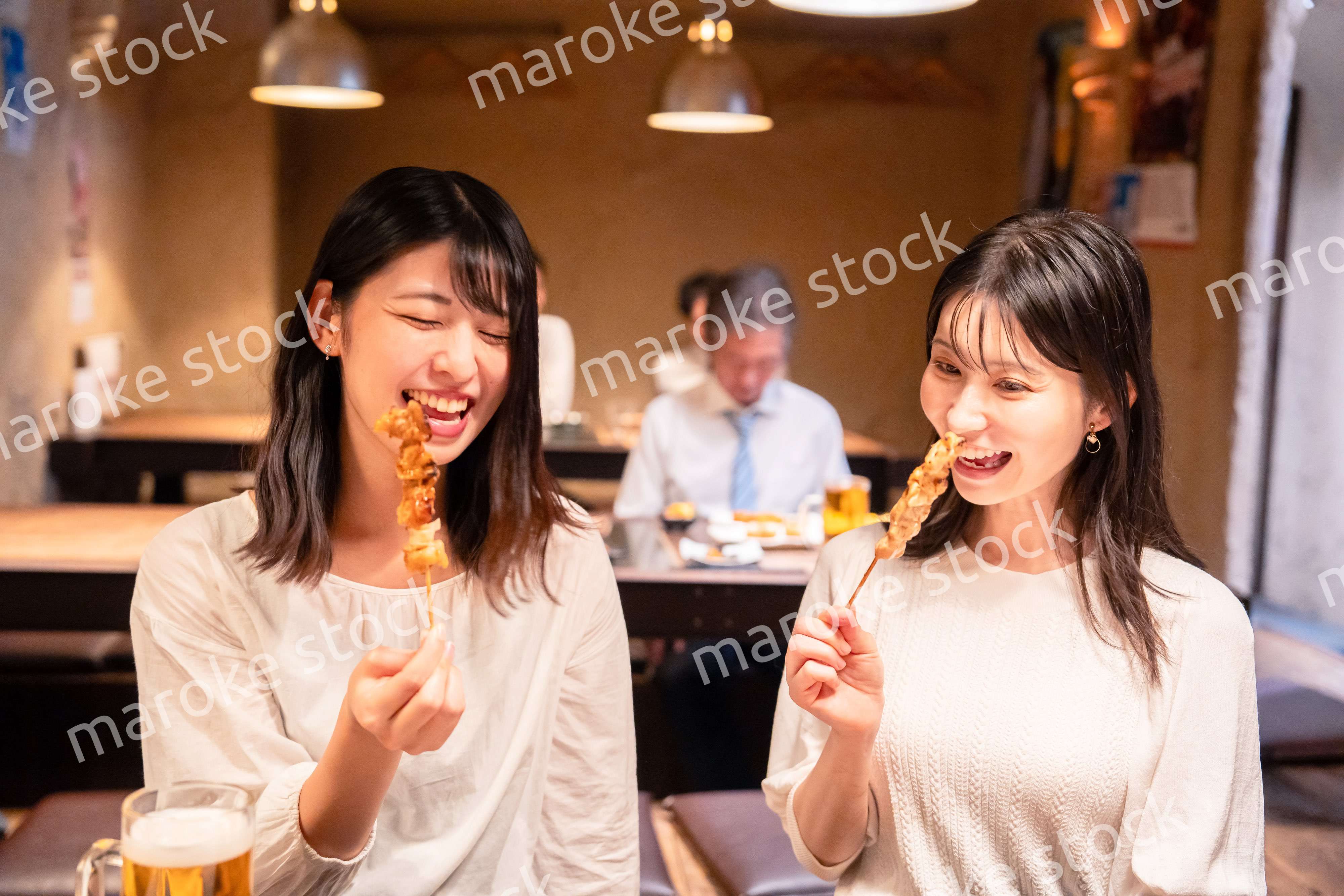 居酒屋で女子会をする二人の女性