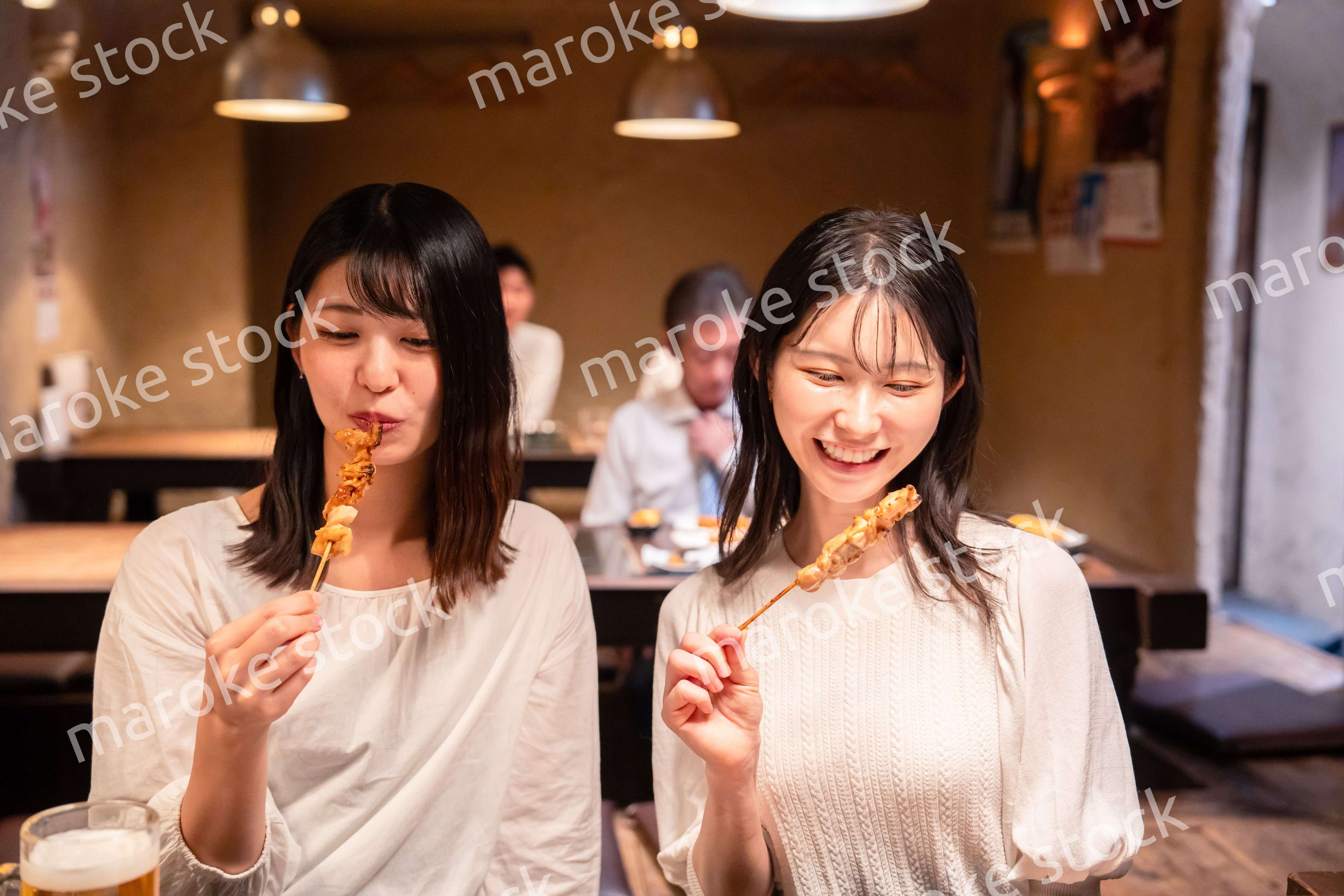 居酒屋で女子会をする二人の女性