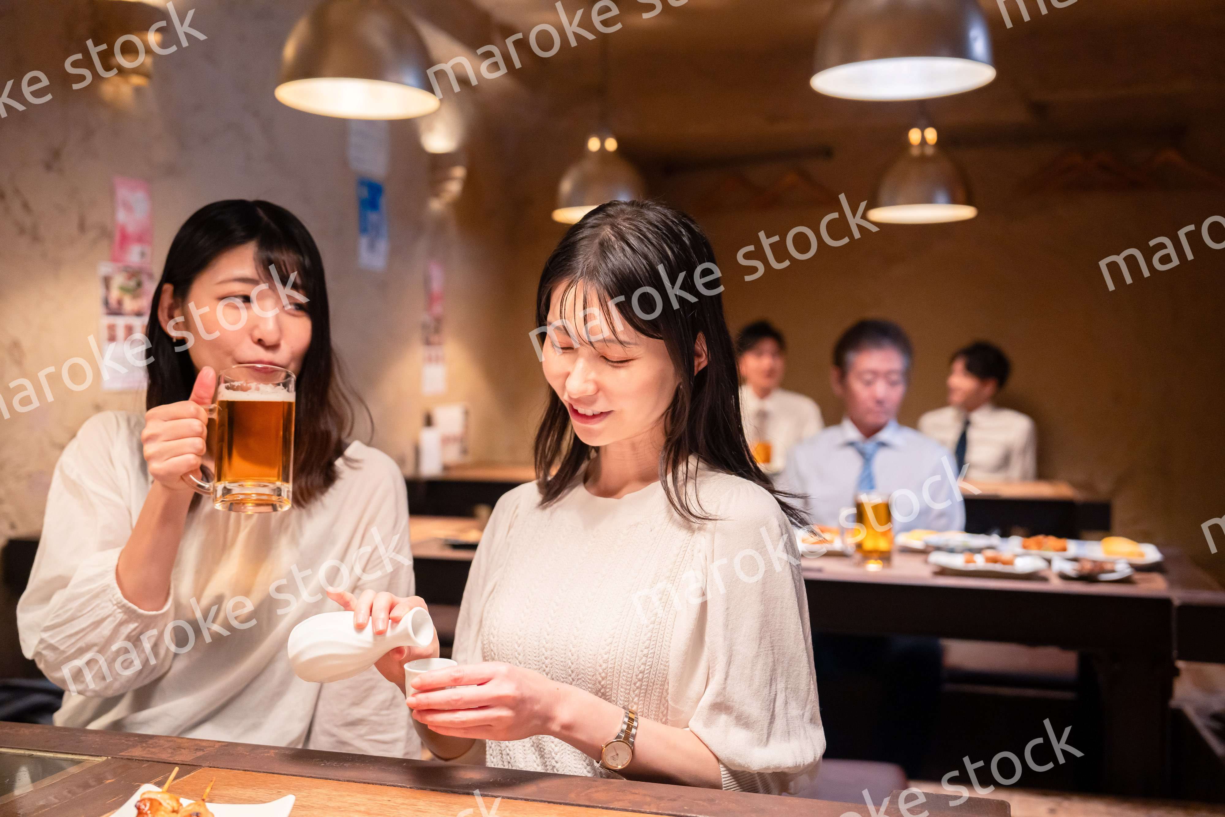 居酒屋で女子会をする二人の女性