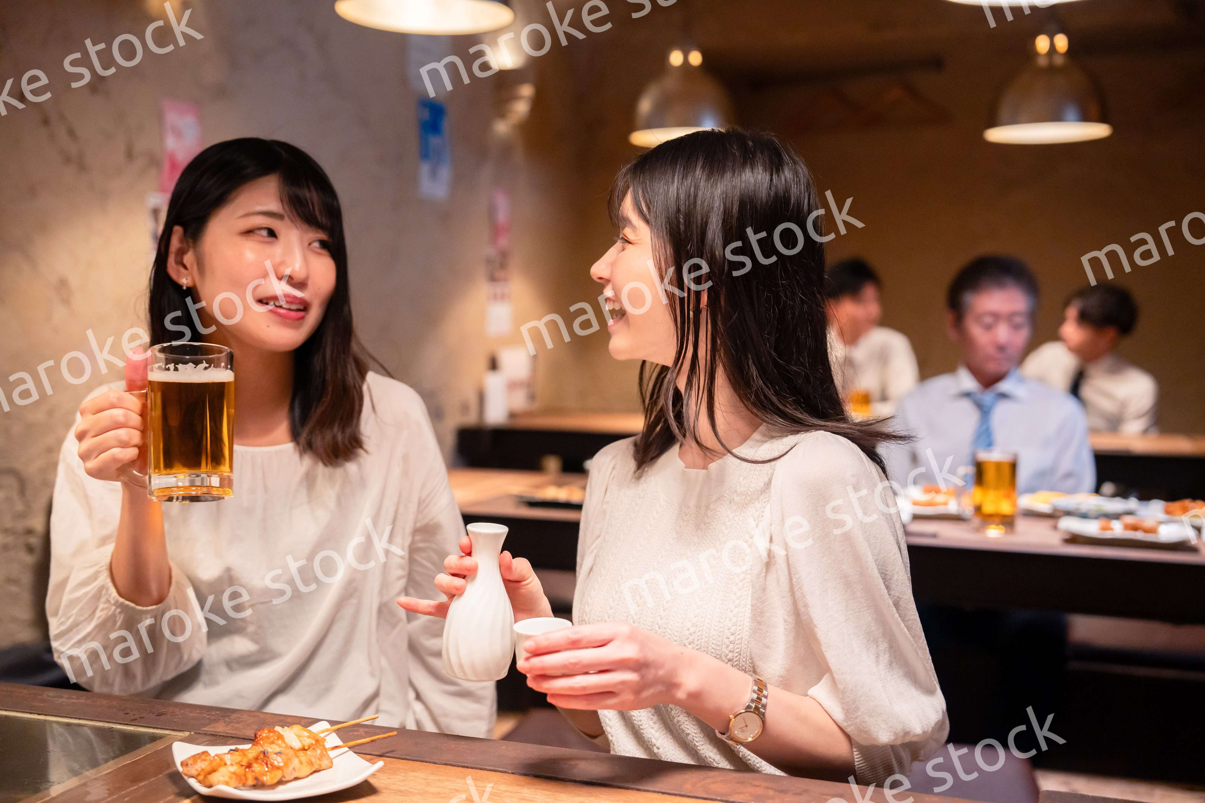 居酒屋で女子会をする二人の女性