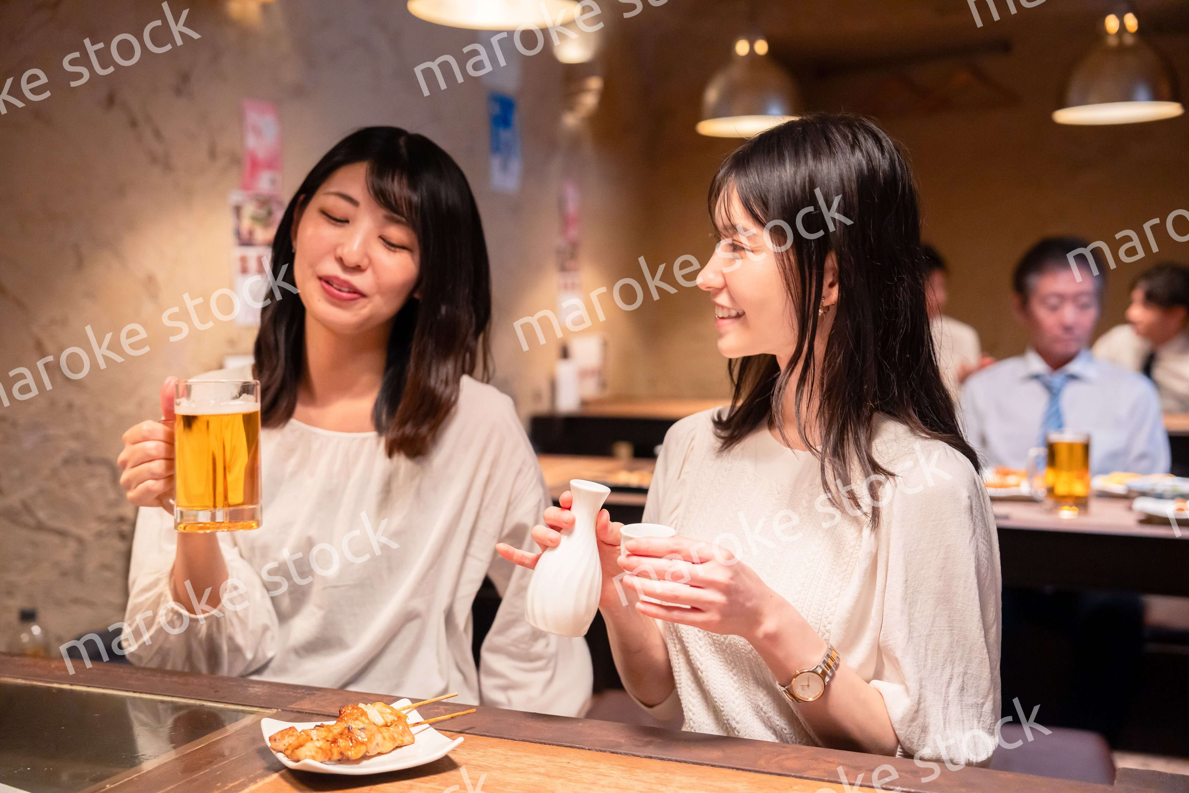 居酒屋で女子会をする二人の女性