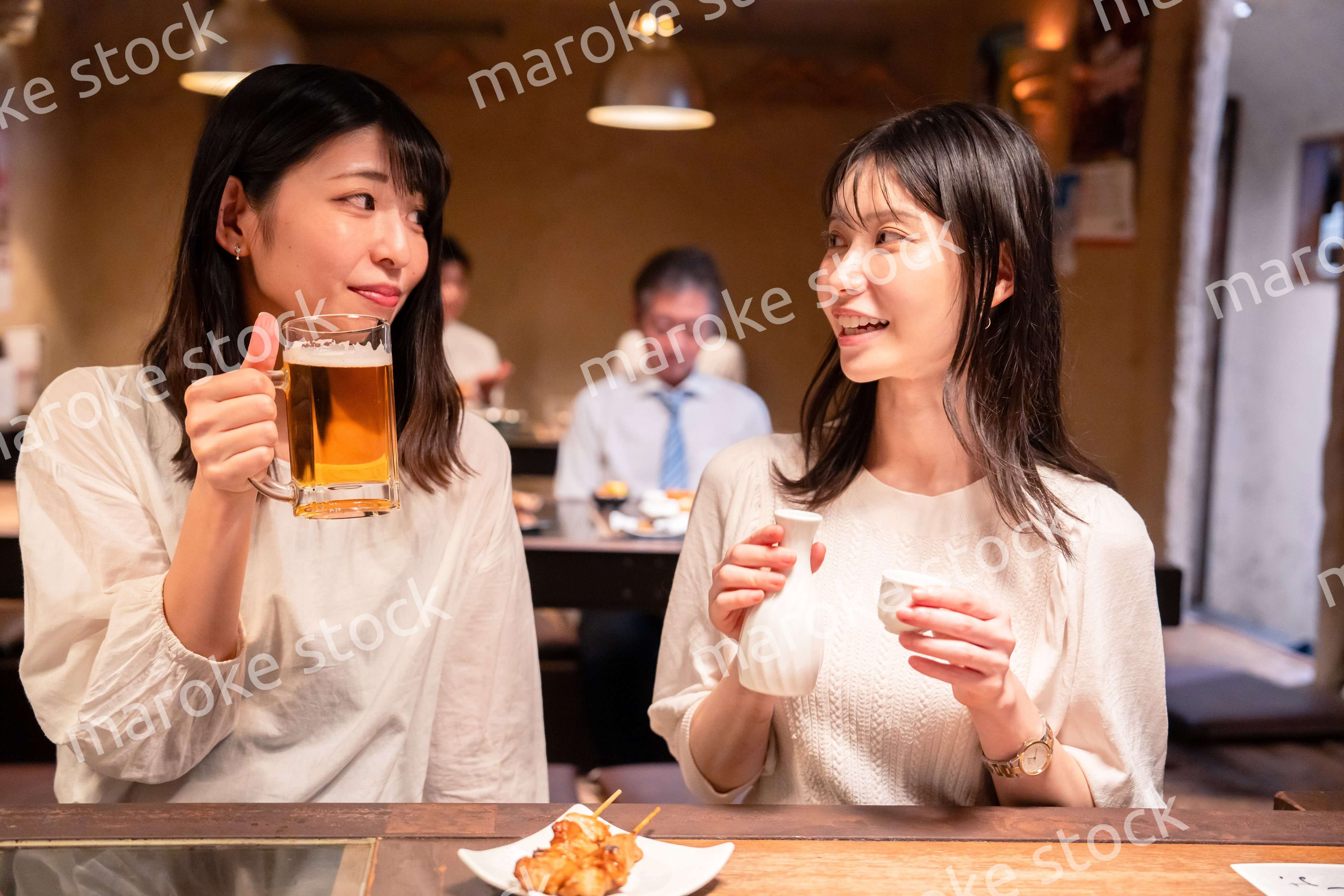 居酒屋で女子会をする二人の女性