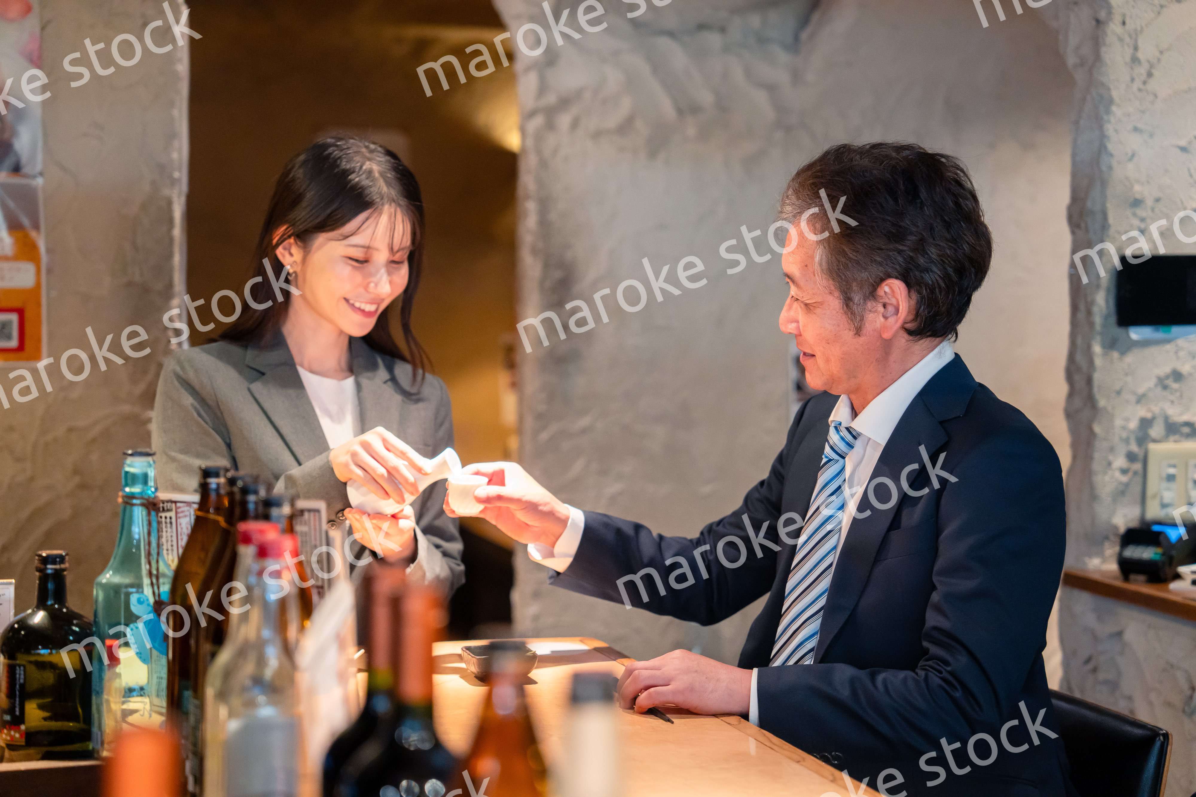 女性とお酒を飲むシニアのビジネスマン