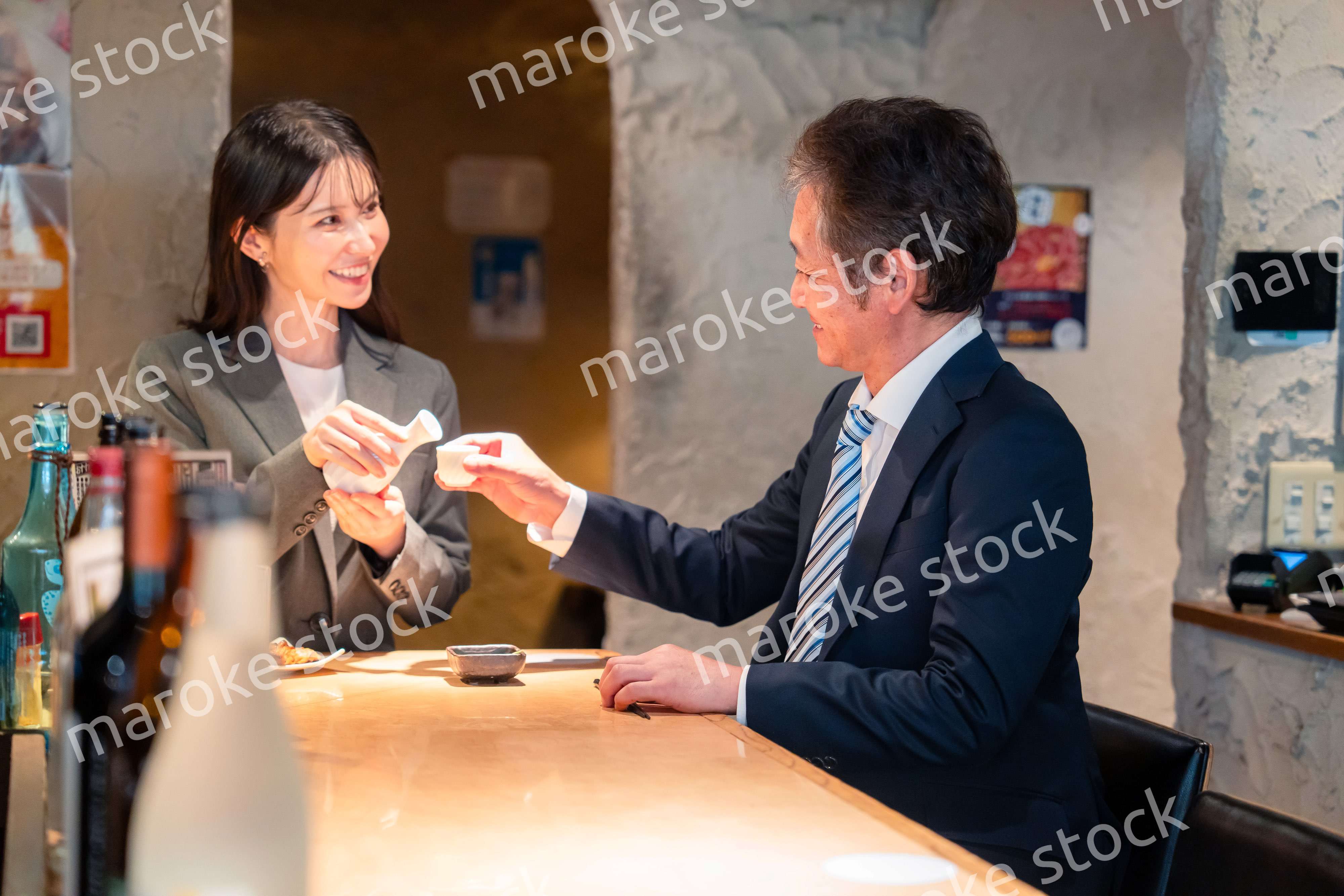 女性とお酒を飲むシニアのビジネスマン