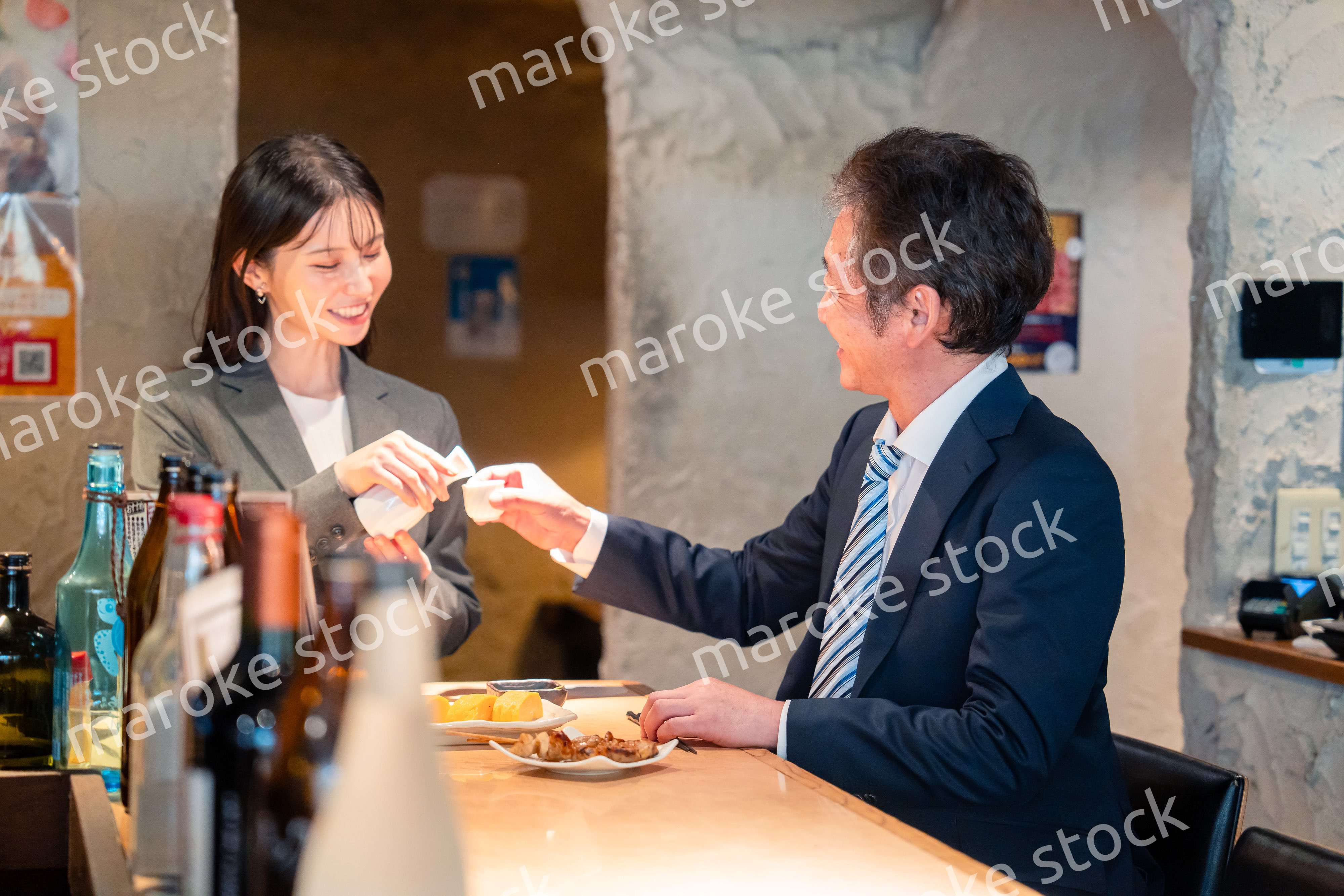 女性とお酒を飲むシニアのビジネスマン