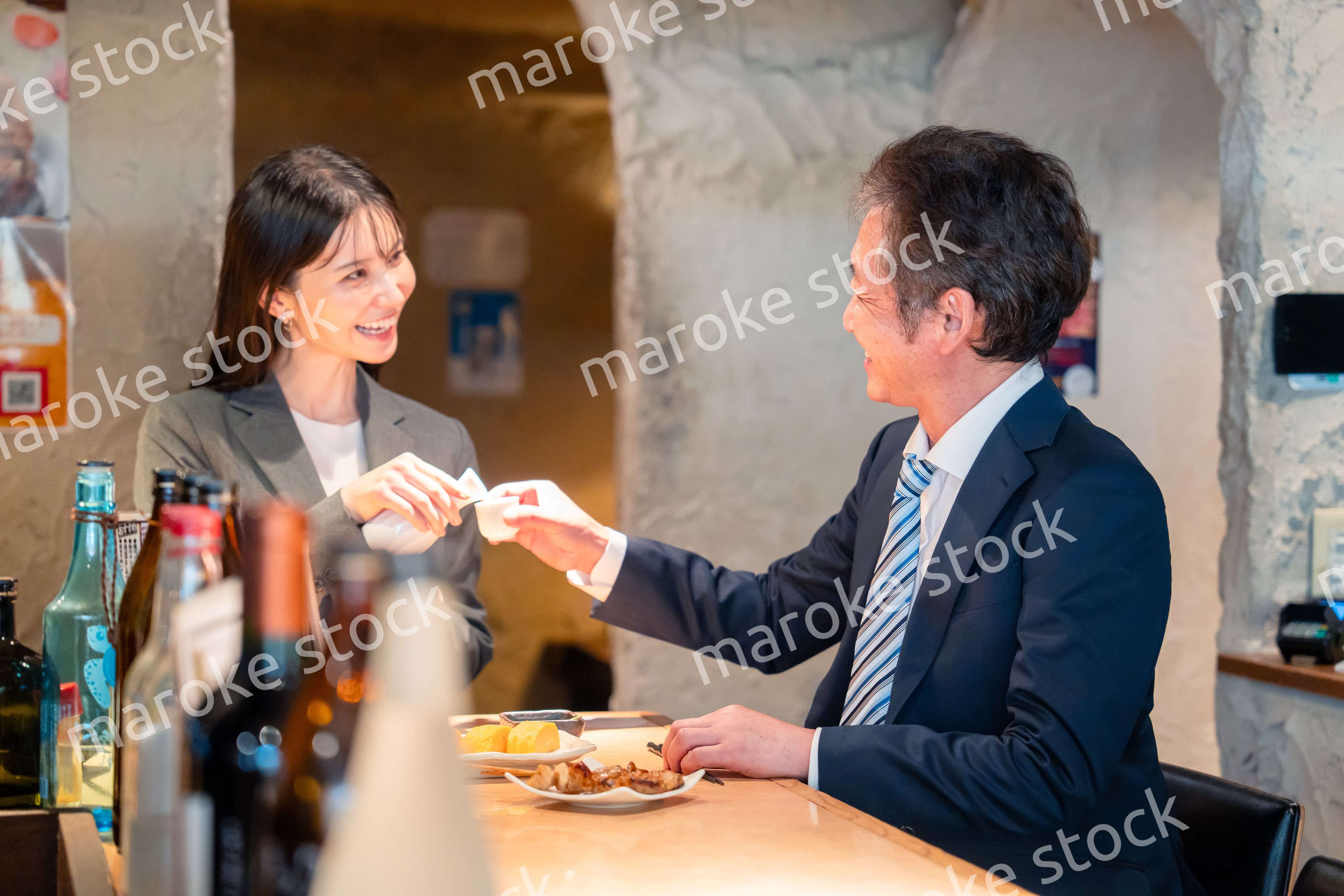 女性とお酒を飲むシニアのビジネスマン