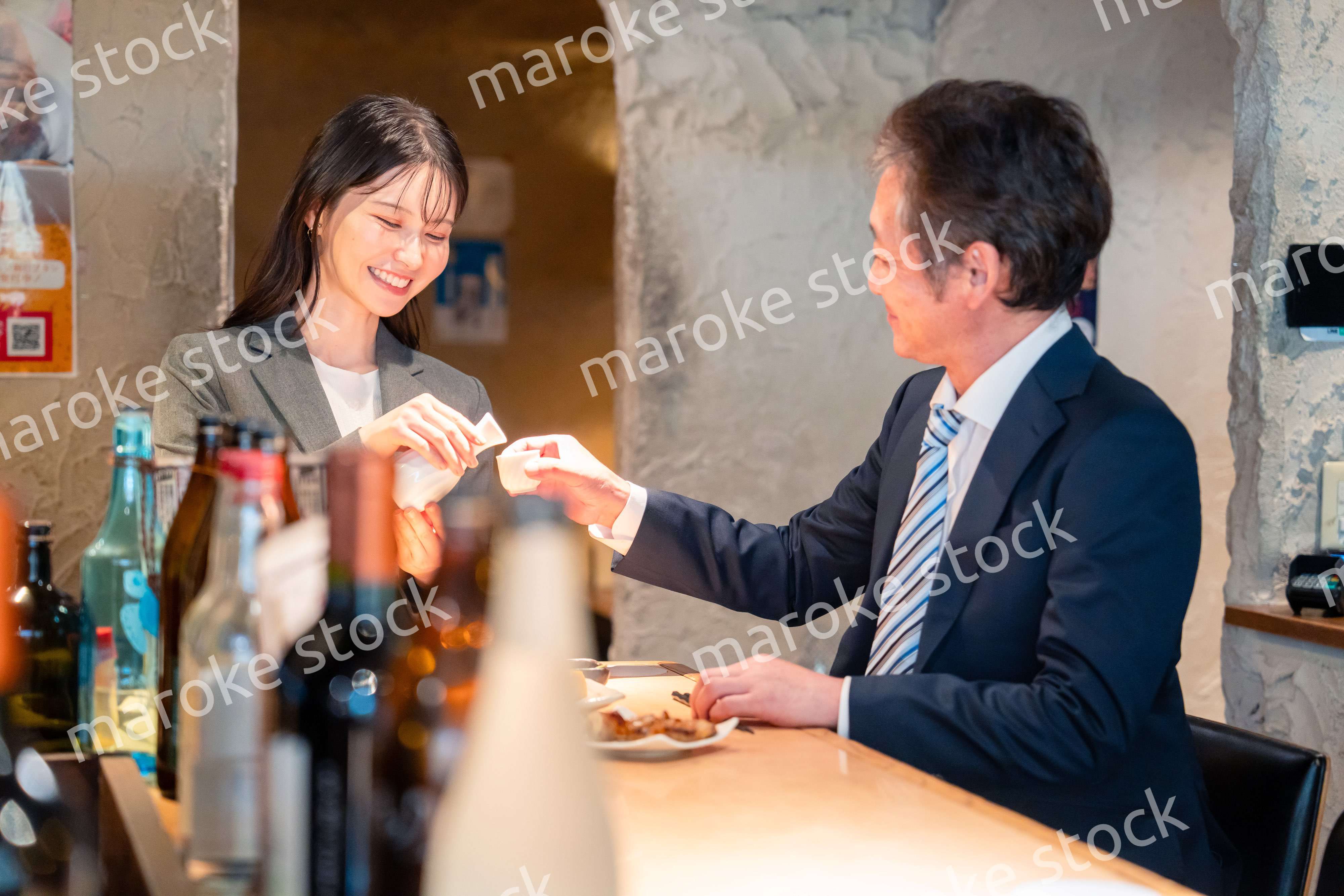 女性とお酒を飲むシニアのビジネスマン
