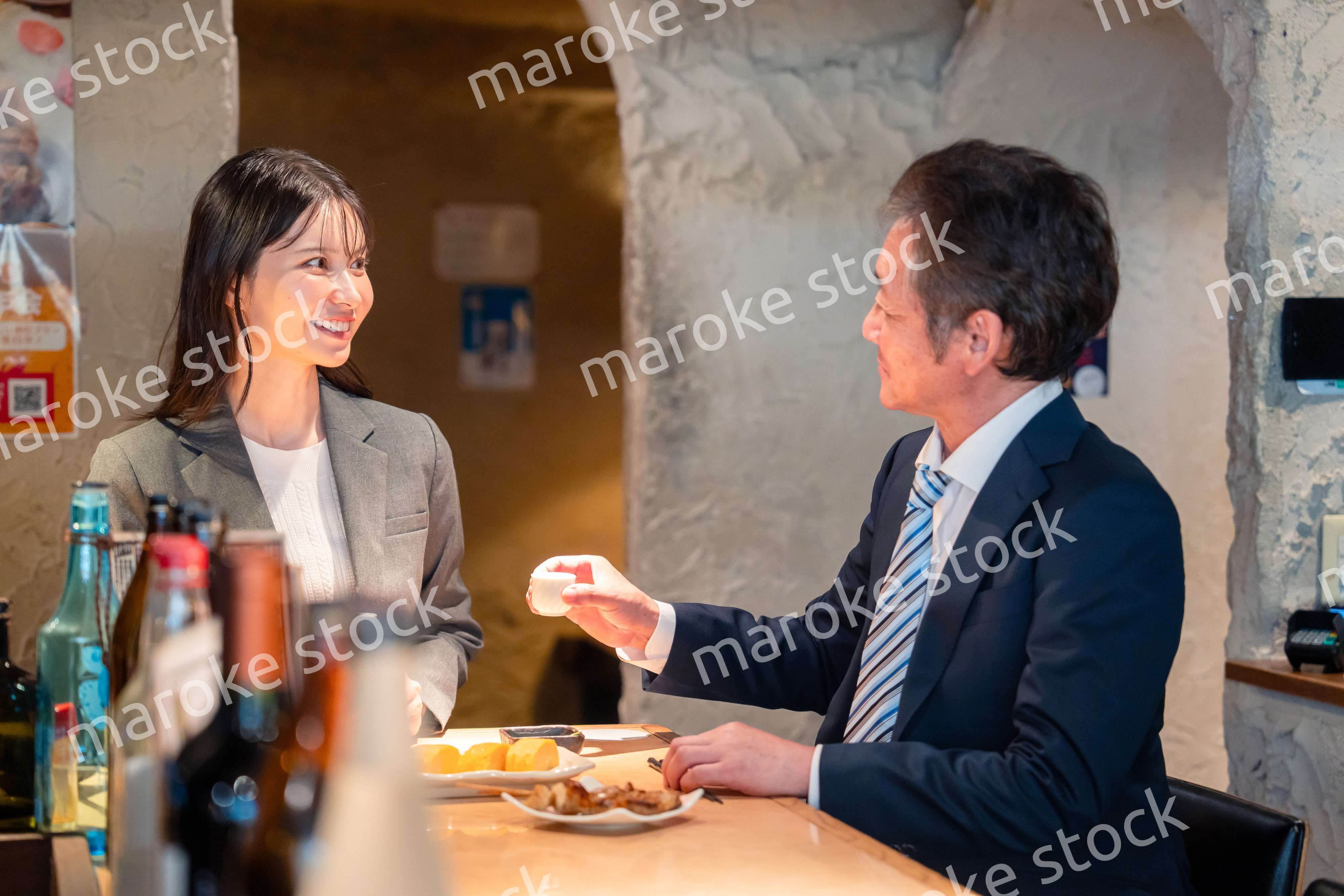 女性とお酒を飲むシニアのビジネスマン