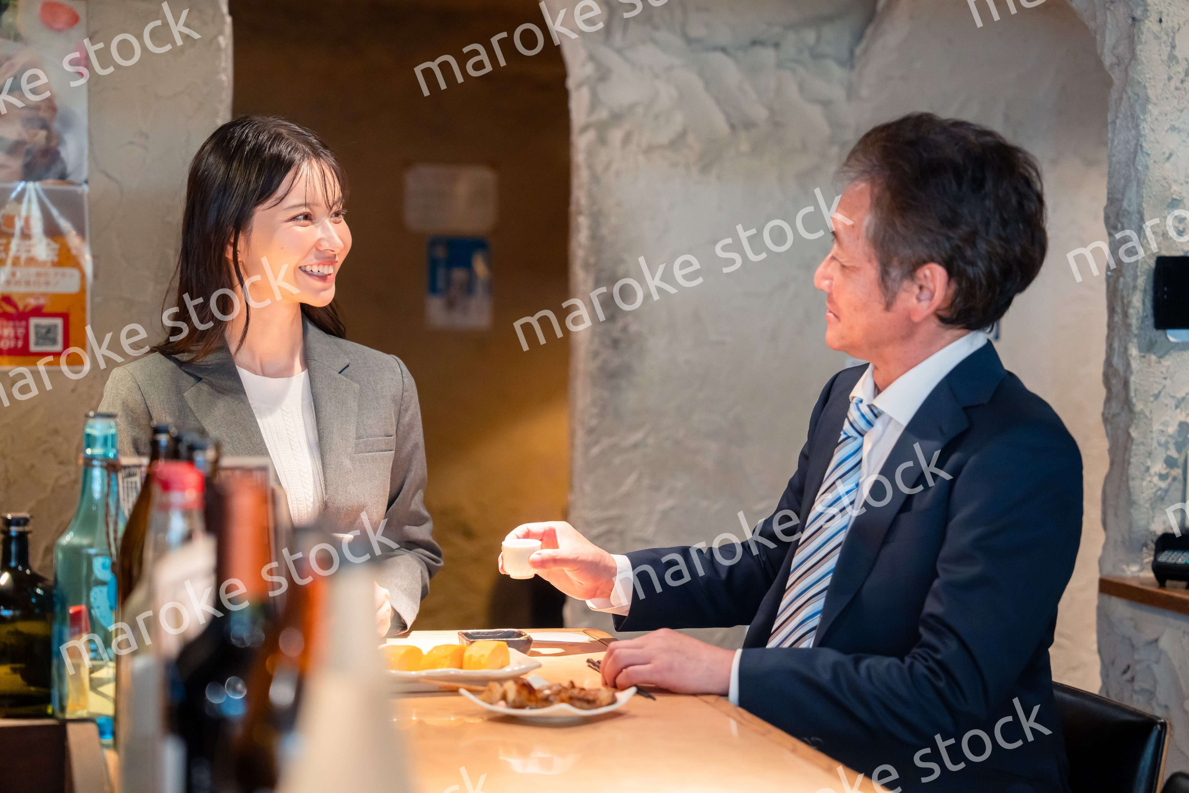 女性とお酒を飲むシニアのビジネスマン