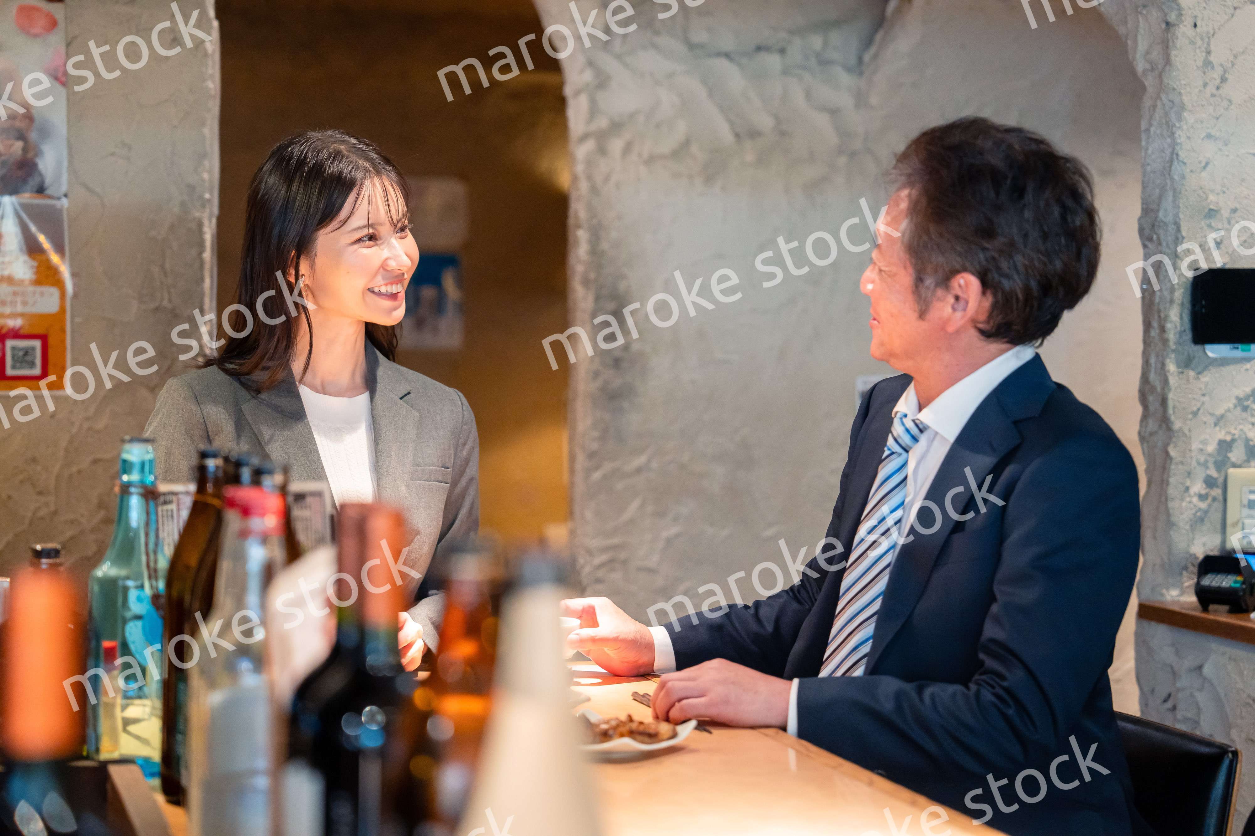 女性とお酒を飲むシニアのビジネスマン