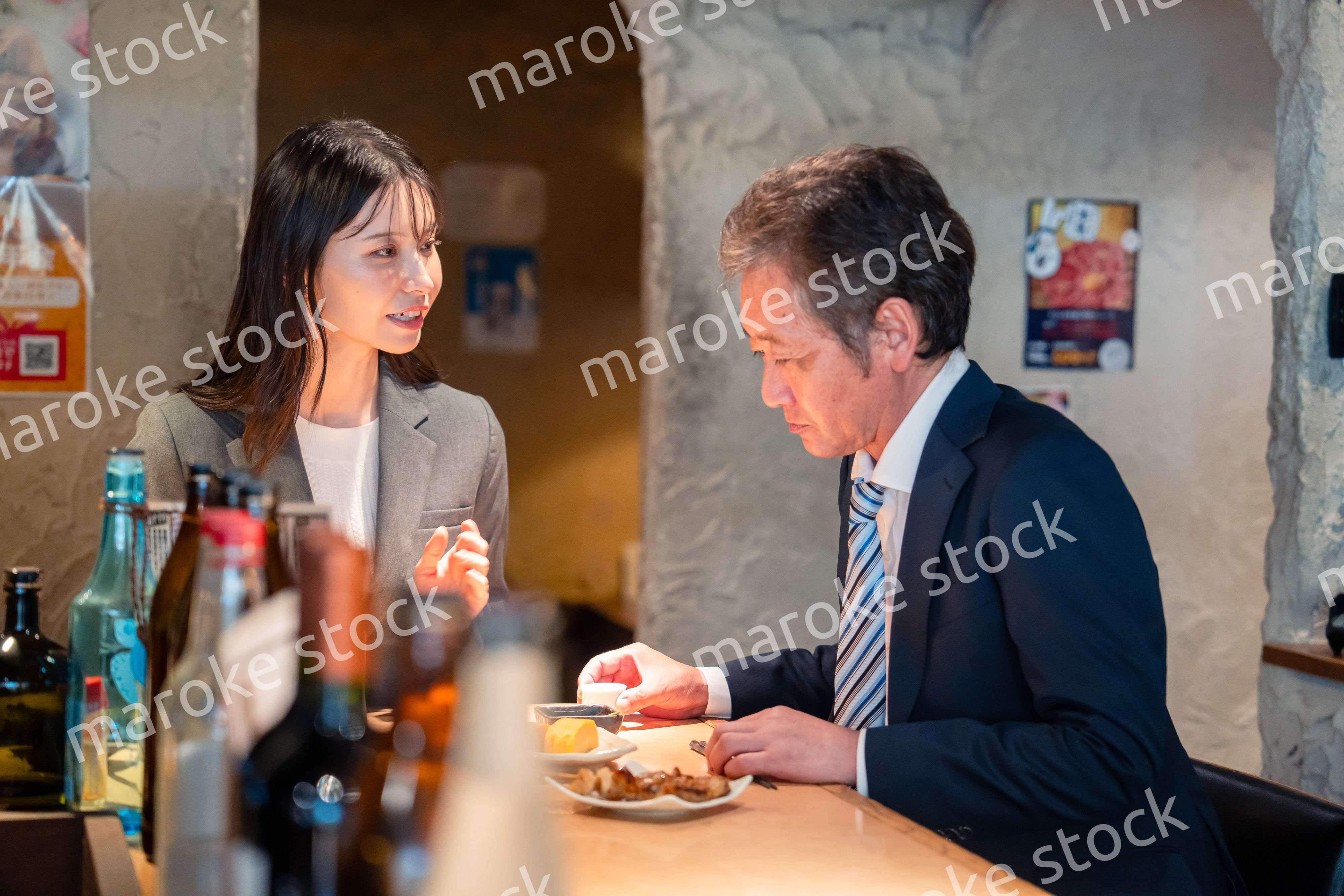 女性とお酒を飲むシニアのビジネスマン