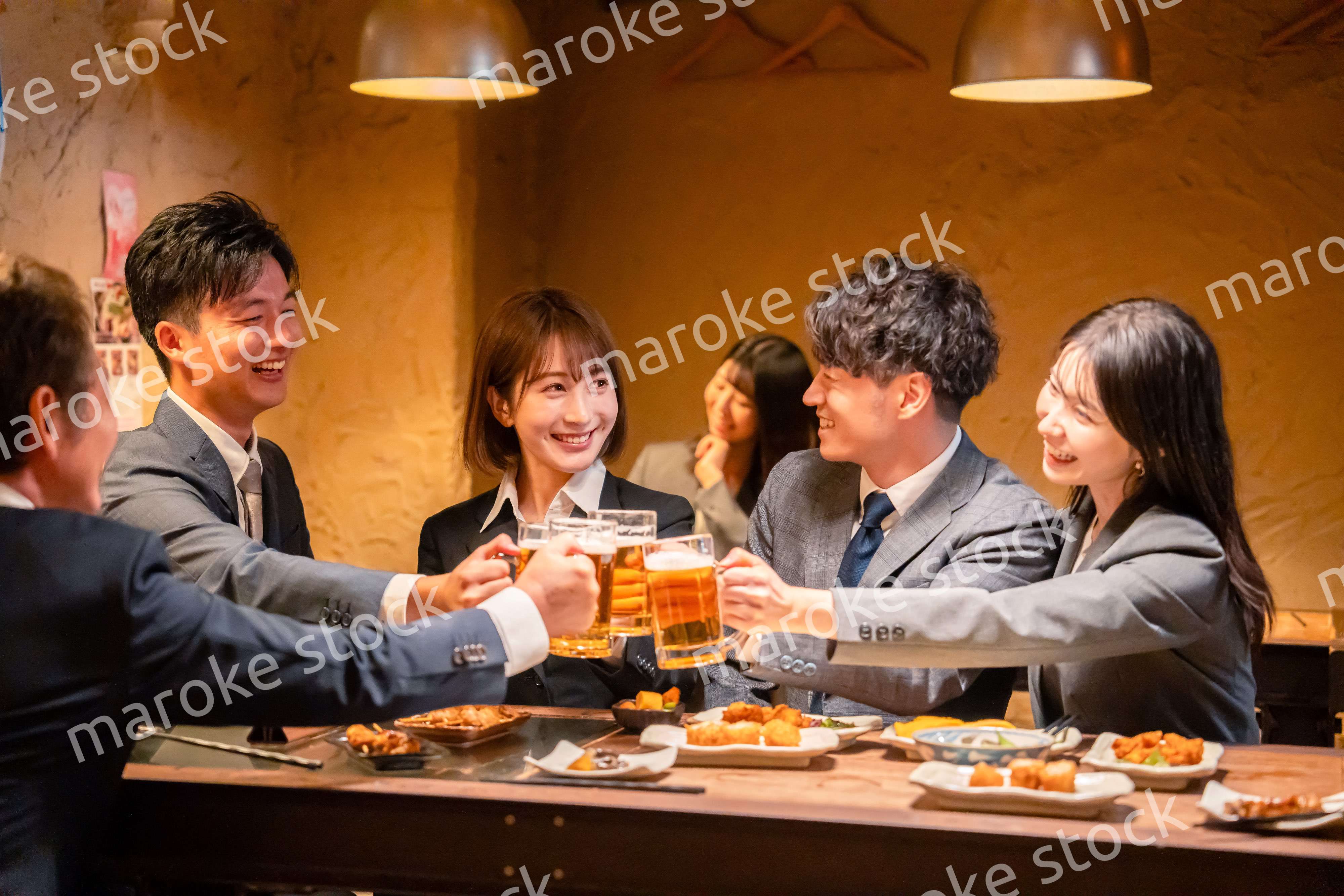 居酒屋で盛大に乾杯をするビジネスパーソン