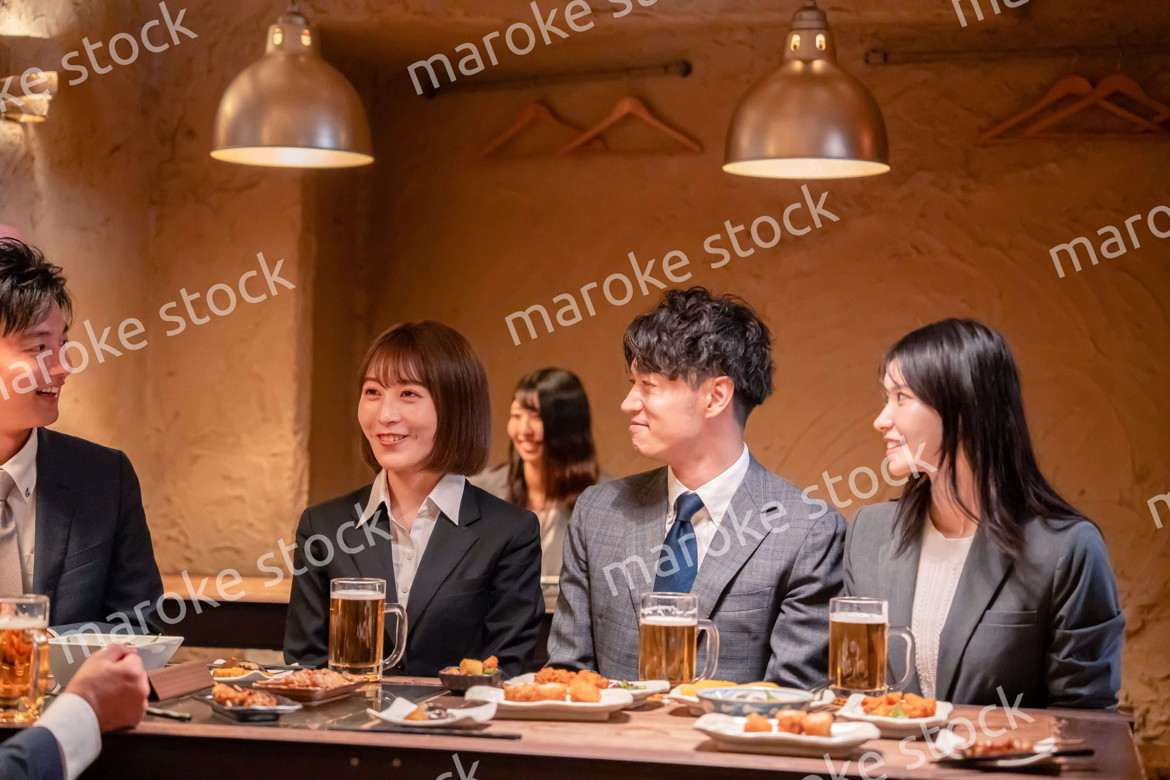 居酒屋で新入社員の歓迎会をするビジネスパーソン