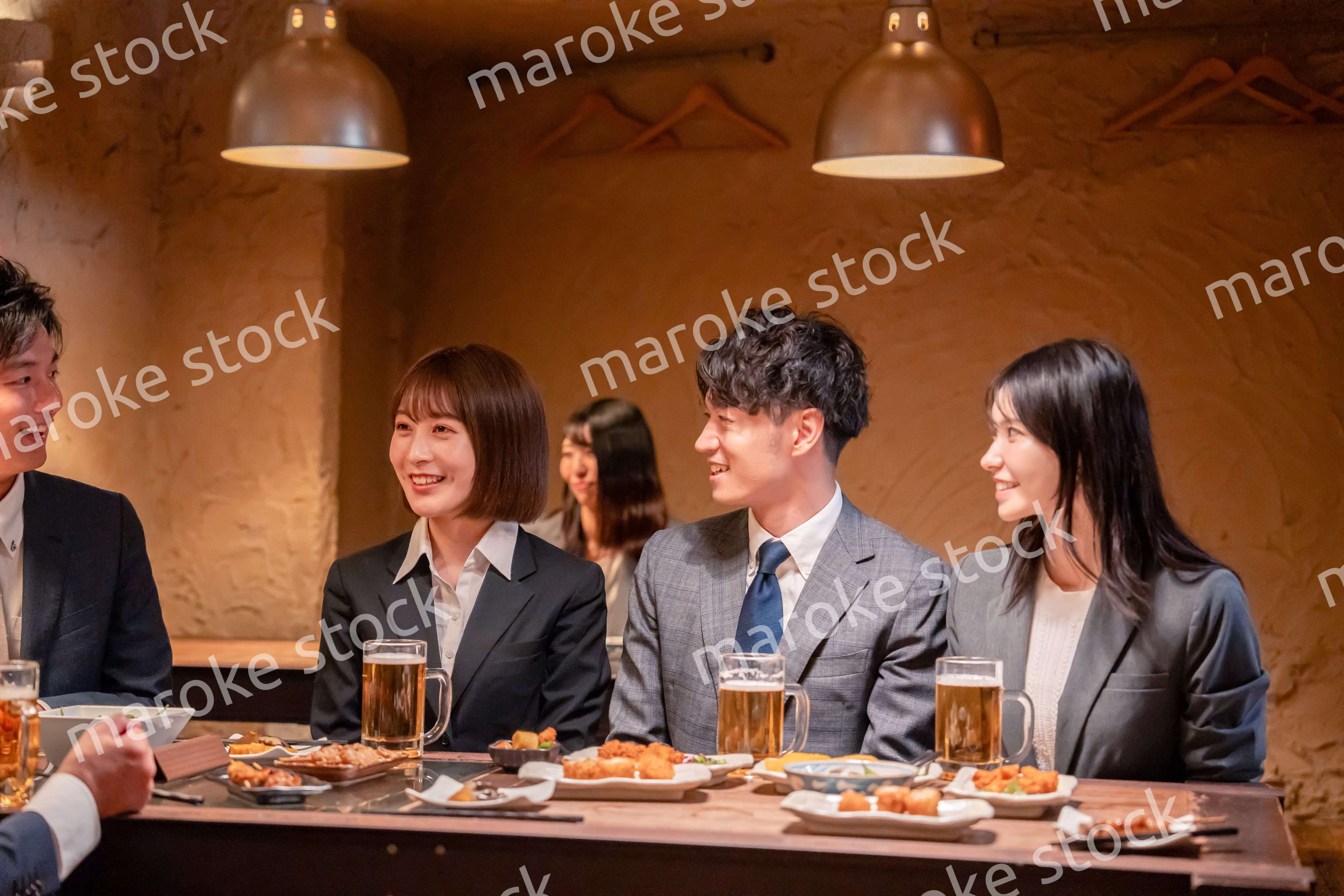 居酒屋で新入社員の歓迎会をするビジネスパーソン