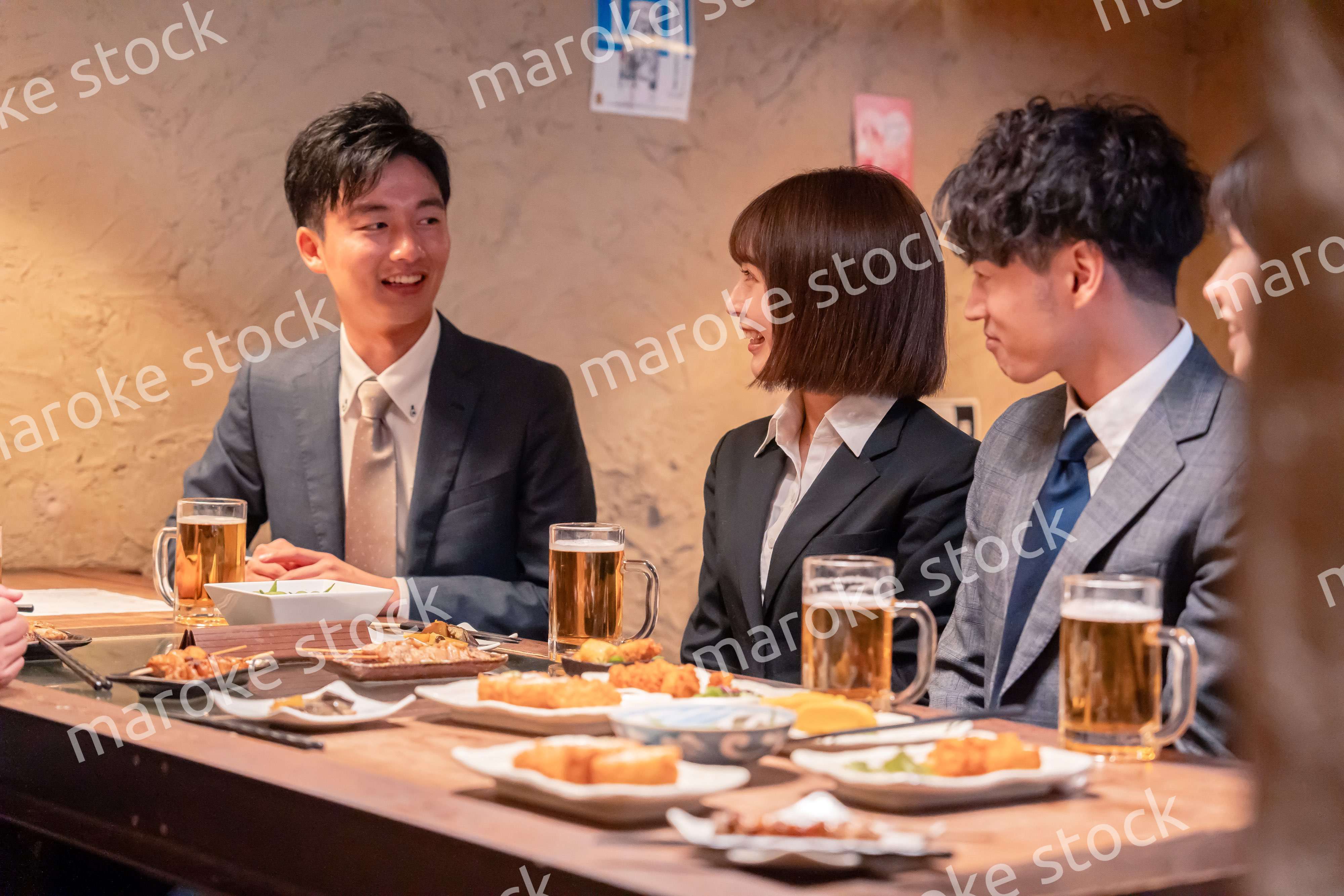 居酒屋で新入社員の歓迎会をするビジネスパーソン