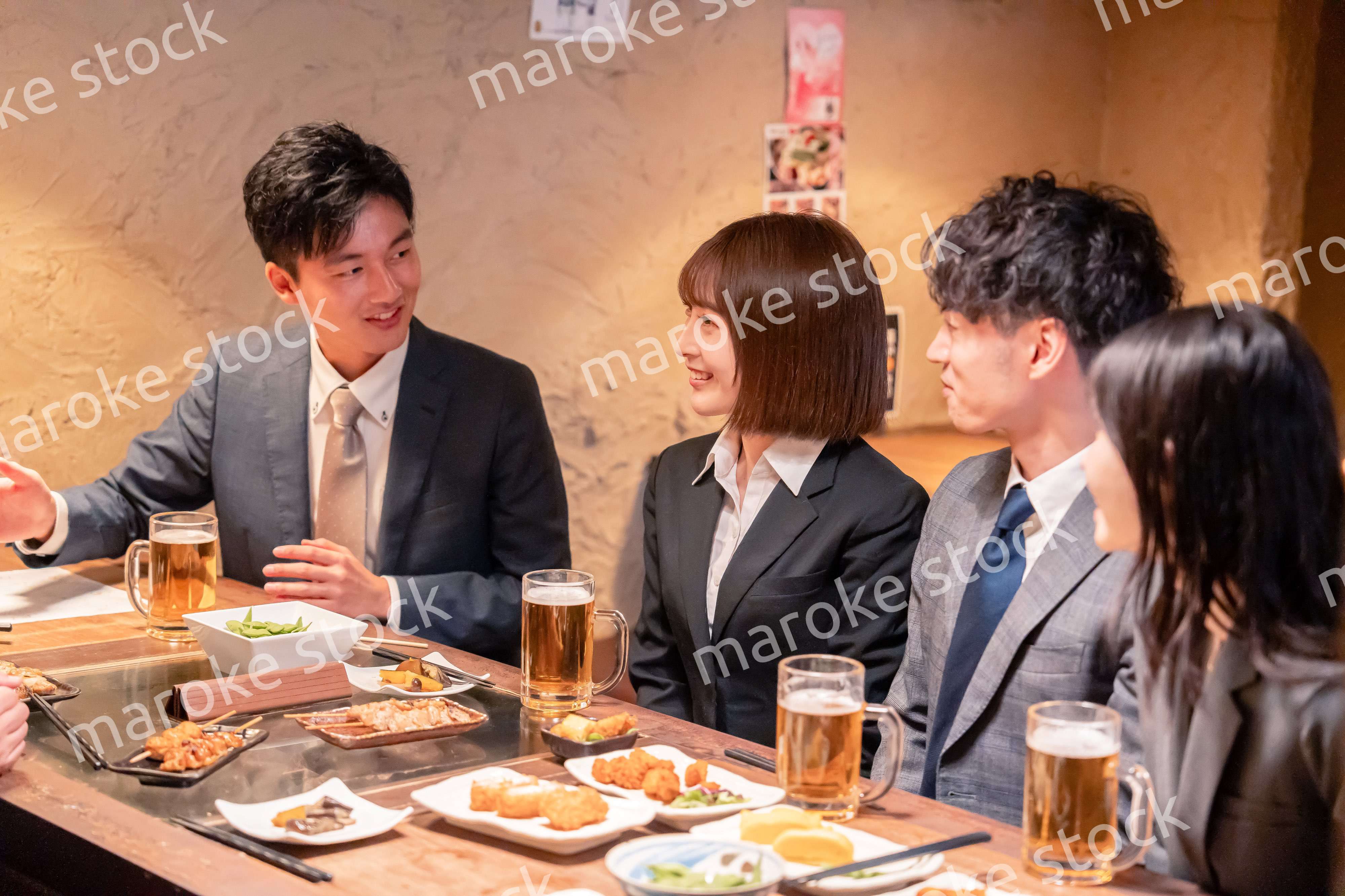 居酒屋で新入社員の歓迎会をするビジネスパーソン