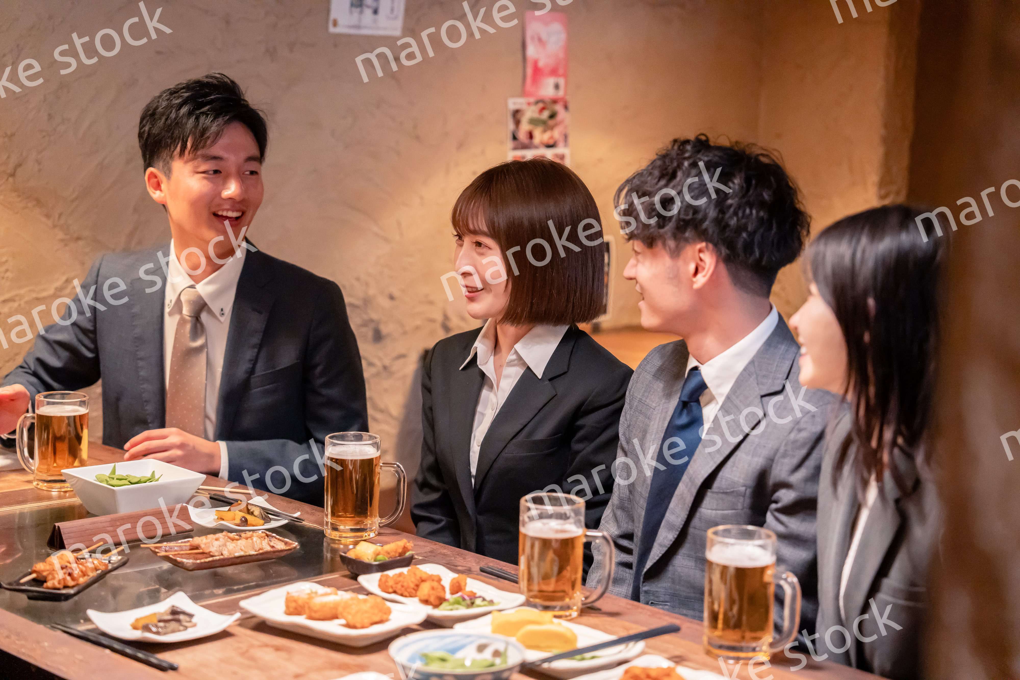 居酒屋で新入社員の歓迎会をするビジネスパーソン