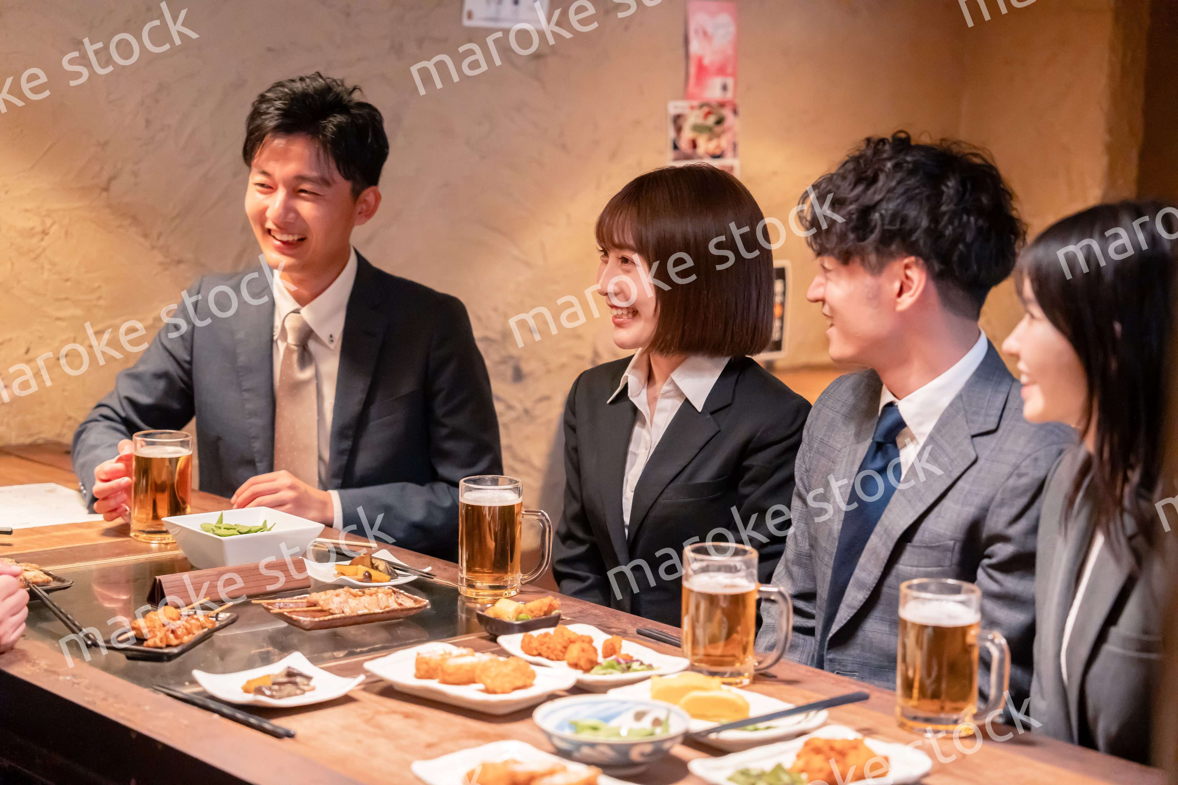 居酒屋で新入社員の歓迎会をするビジネスパーソン