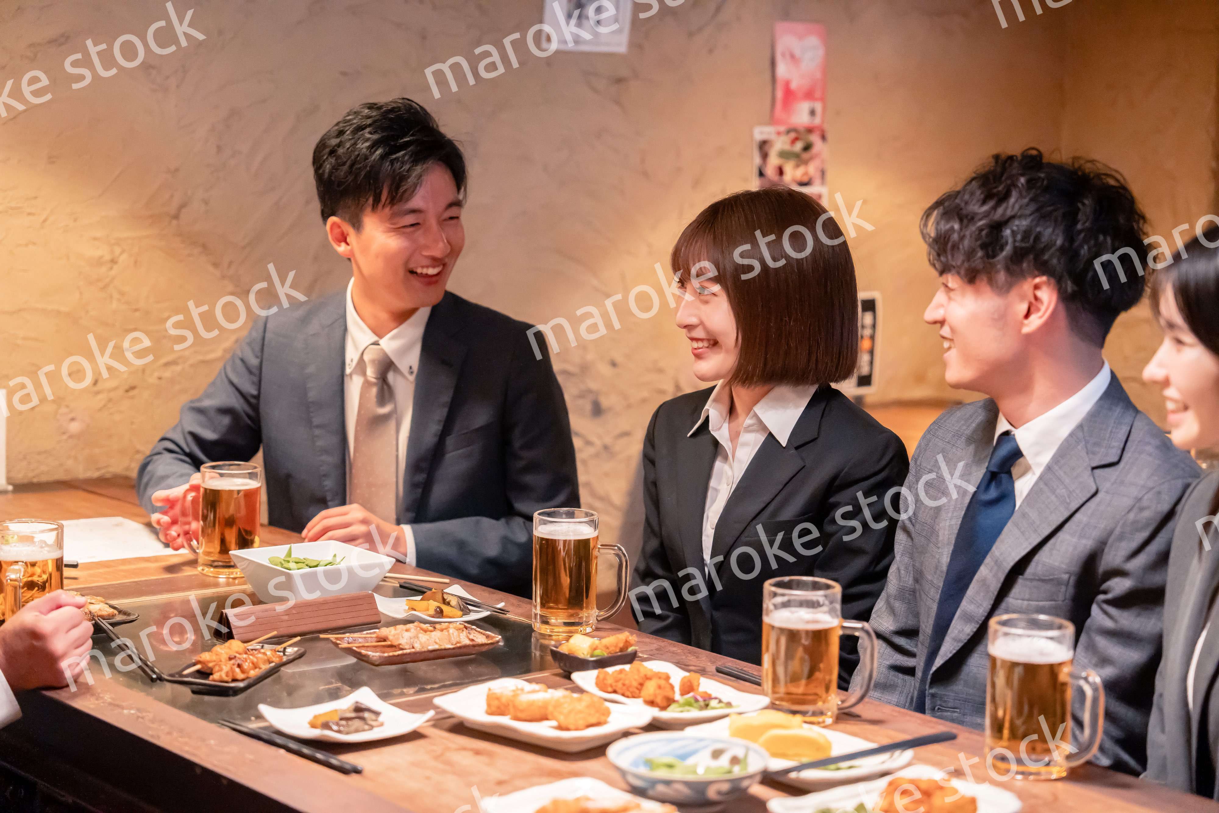 居酒屋で新入社員の歓迎会をするビジネスパーソン