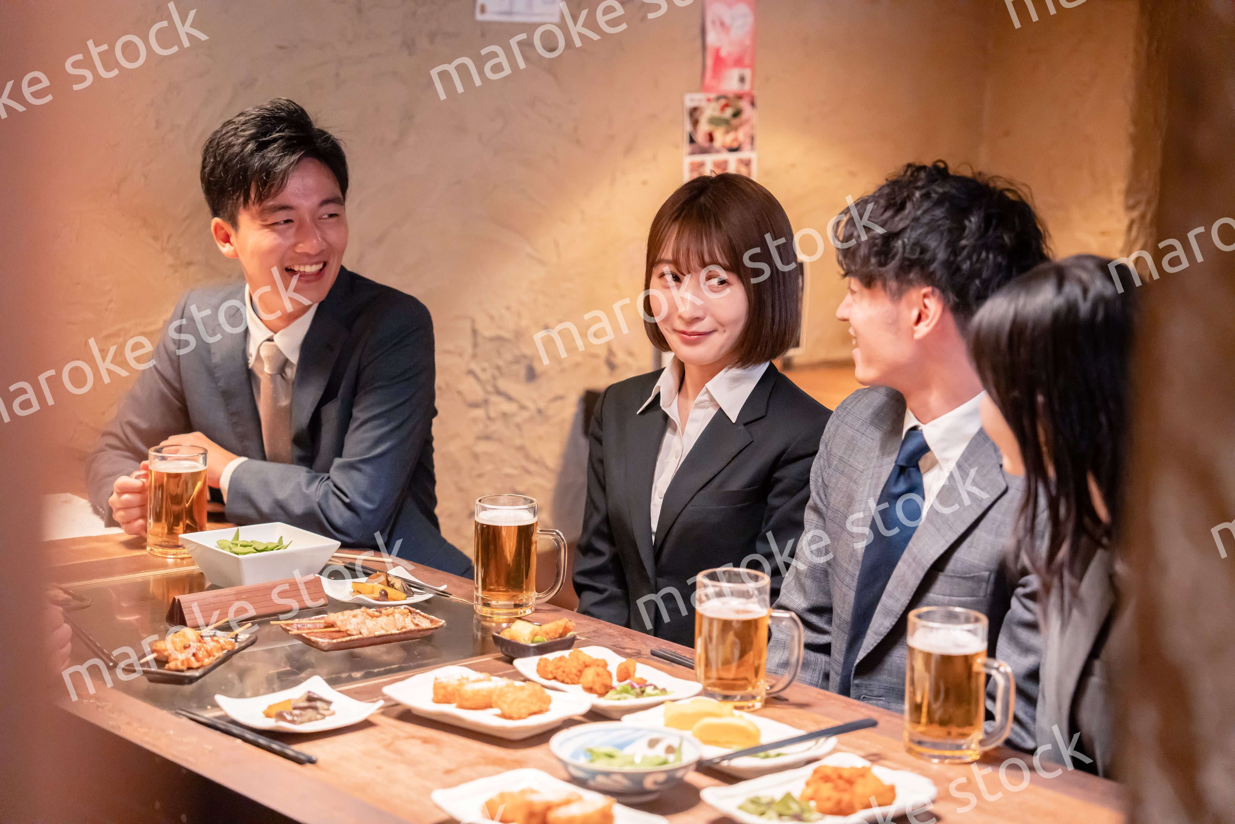 居酒屋で新入社員の歓迎会をするビジネスパーソン