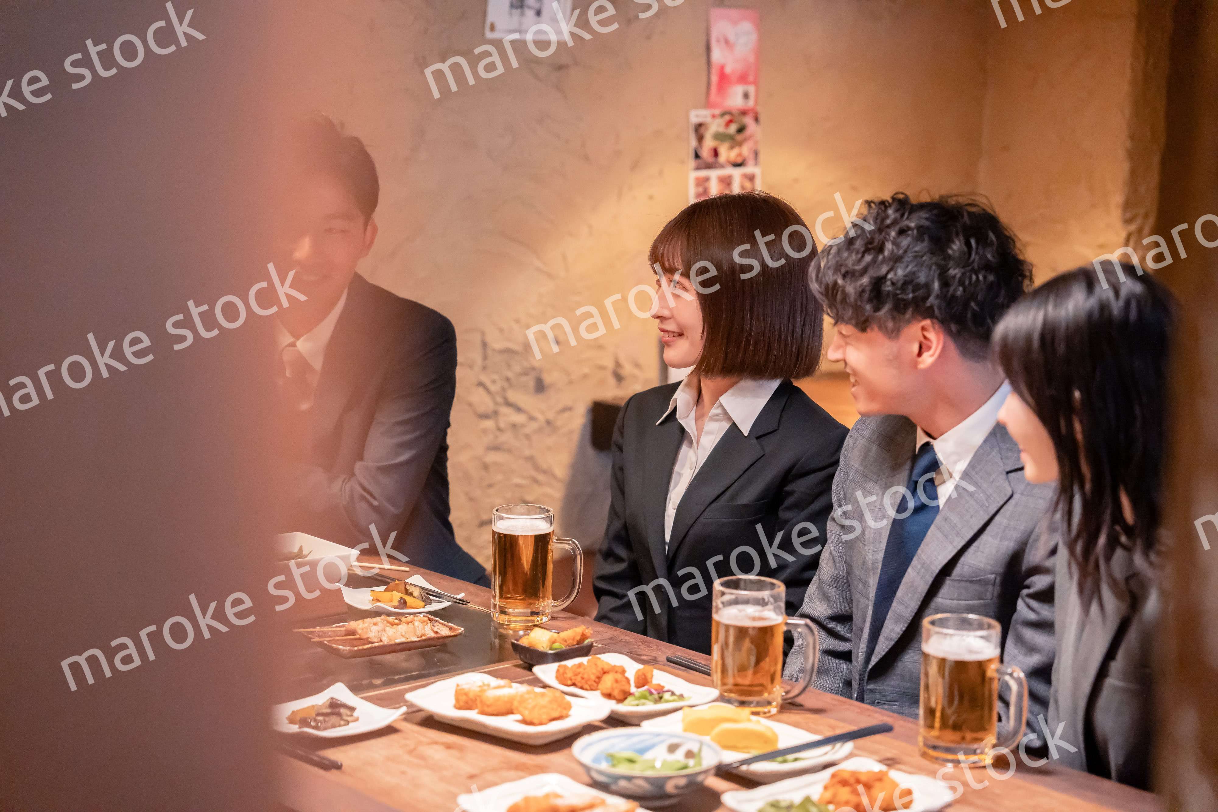 居酒屋で新入社員の歓迎会をするビジネスパーソン