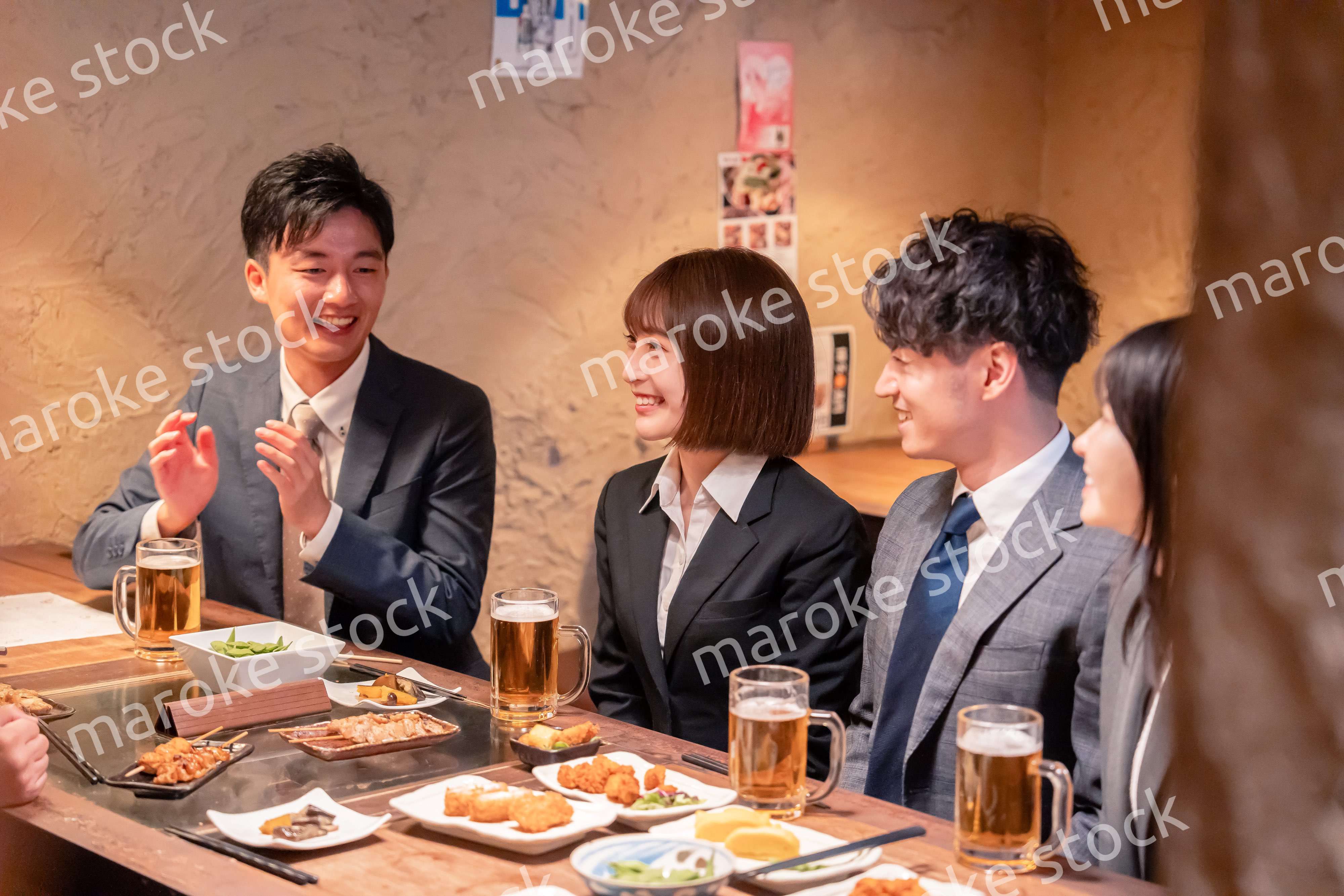 居酒屋で新入社員の歓迎会をするビジネスパーソン