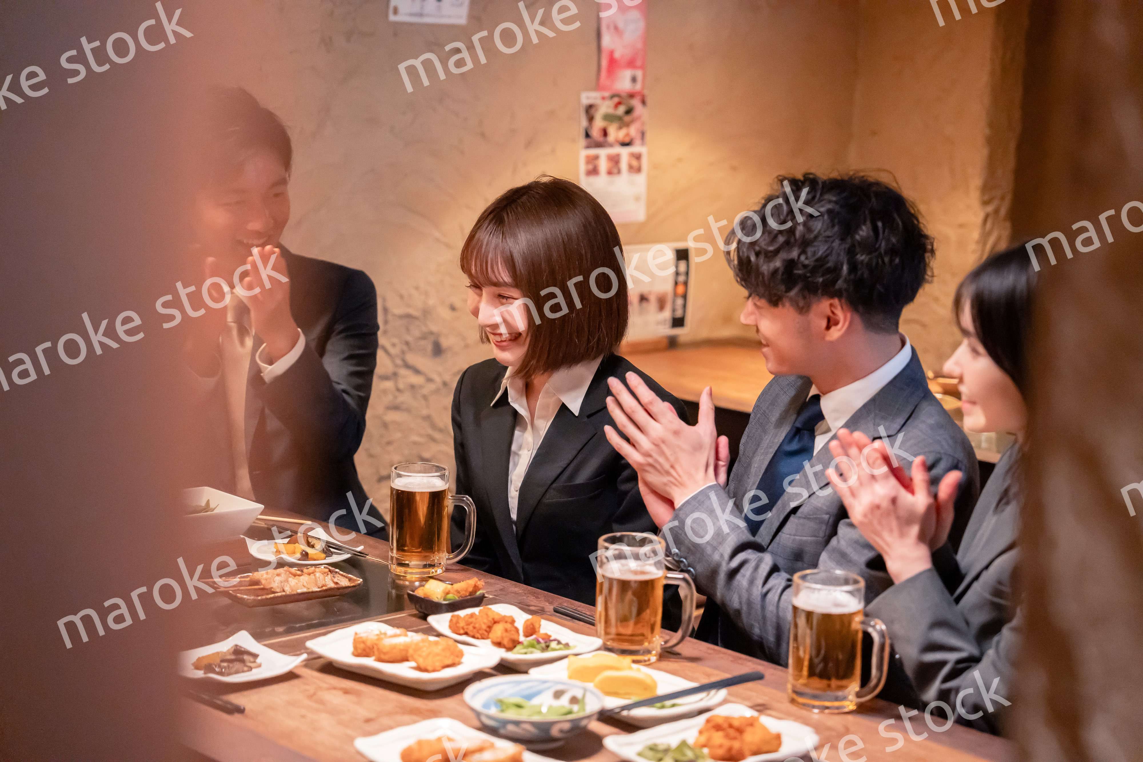 居酒屋で新入社員の歓迎会をするビジネスパーソン