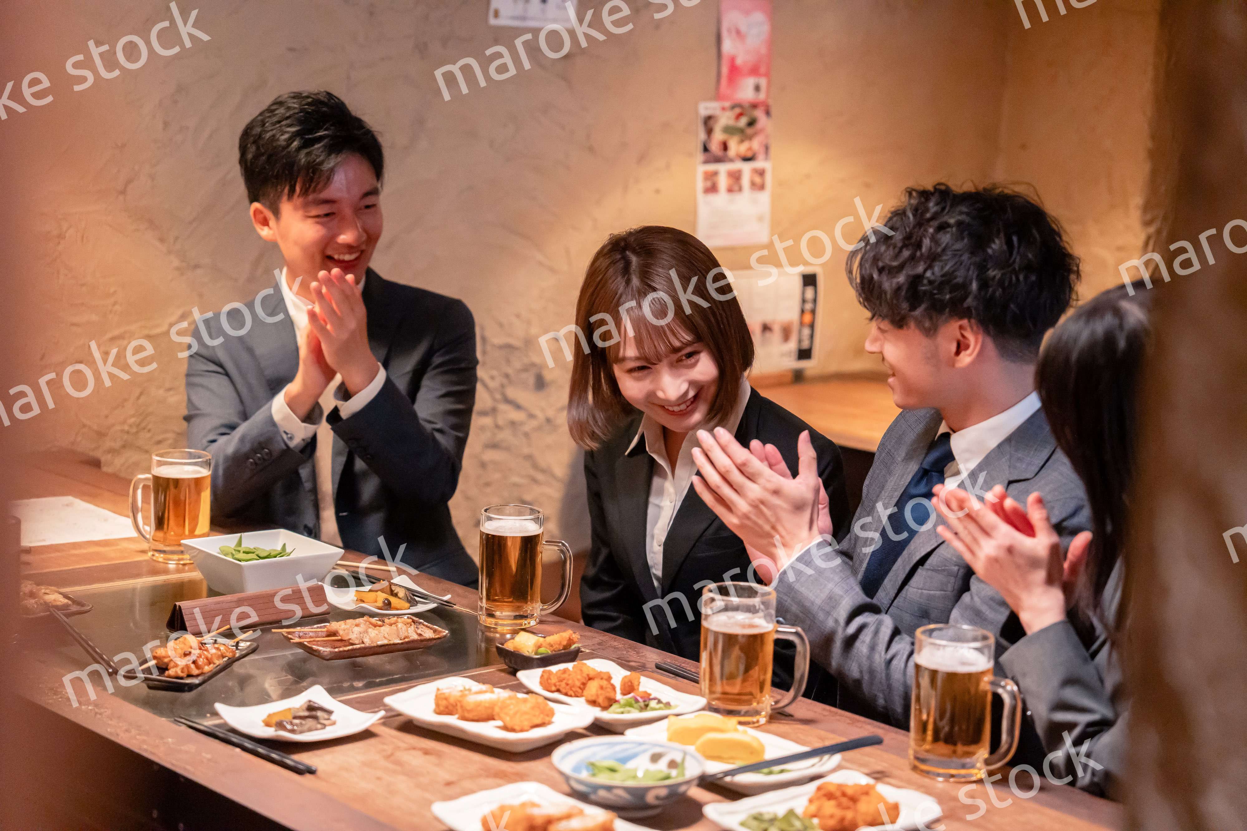 居酒屋で新入社員の歓迎会をするビジネスパーソン