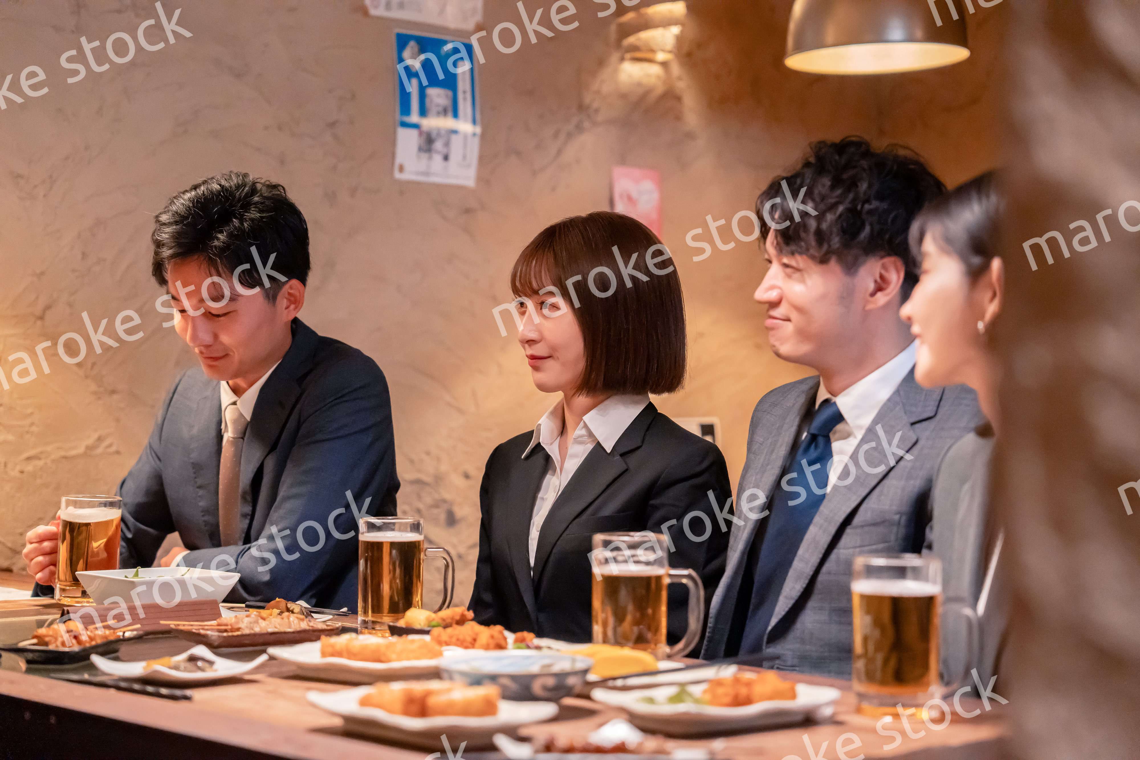 居酒屋で新入社員の歓迎会をするビジネスパーソン