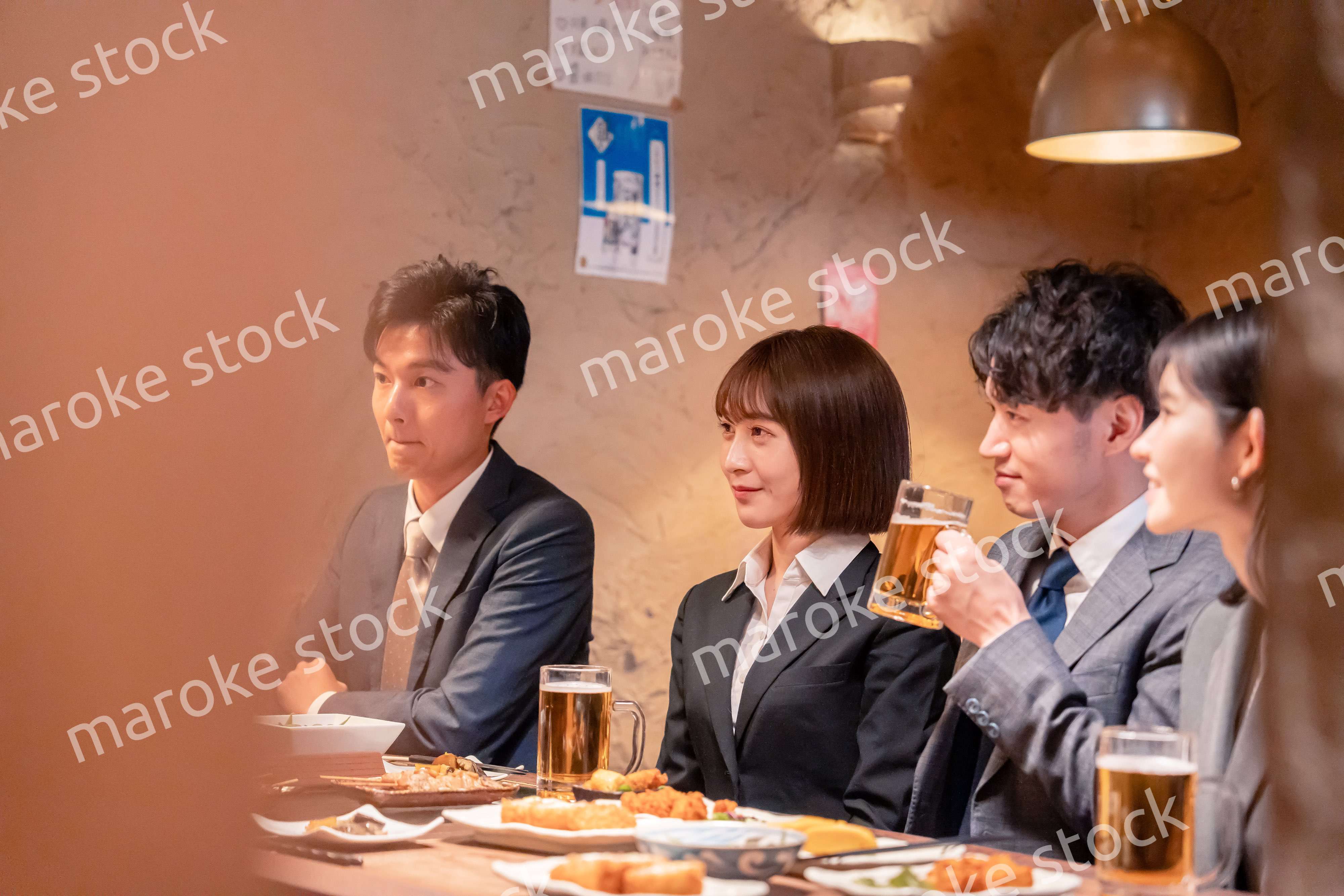 居酒屋で新入社員の歓迎会をするビジネスパーソン